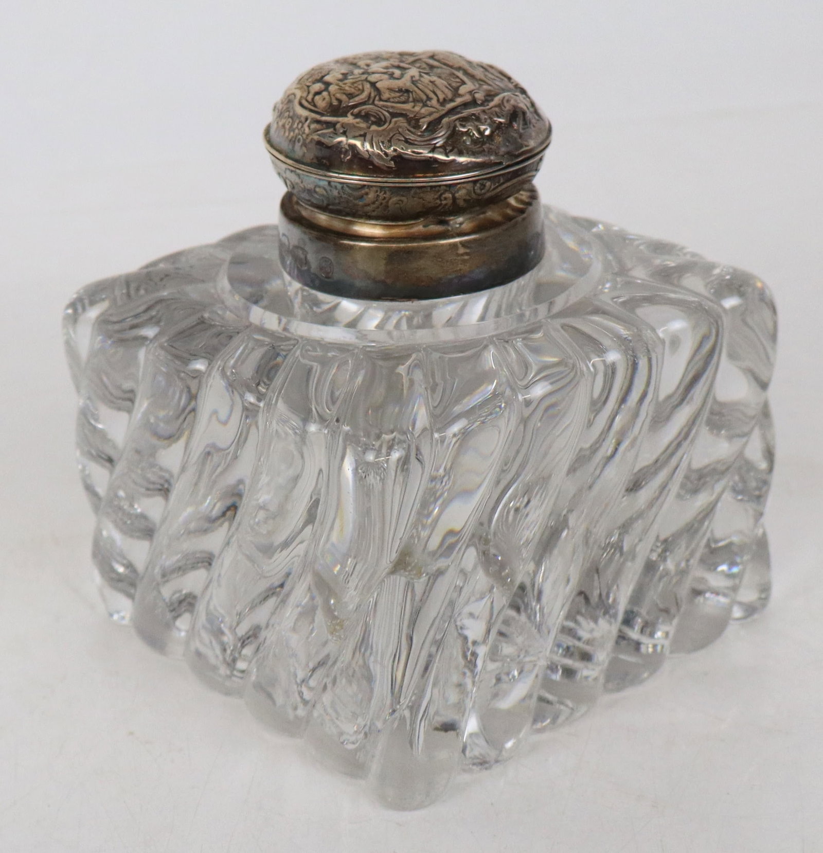 English Silver and Glass Inkwell: English silver and swirled glass inkwell, Edinburgh, 1899, maker's mark rubbed, with classical landscape repoussed top, marks to collar. [5" H x 4" Square]. Overall condition is fair, with chips to gl