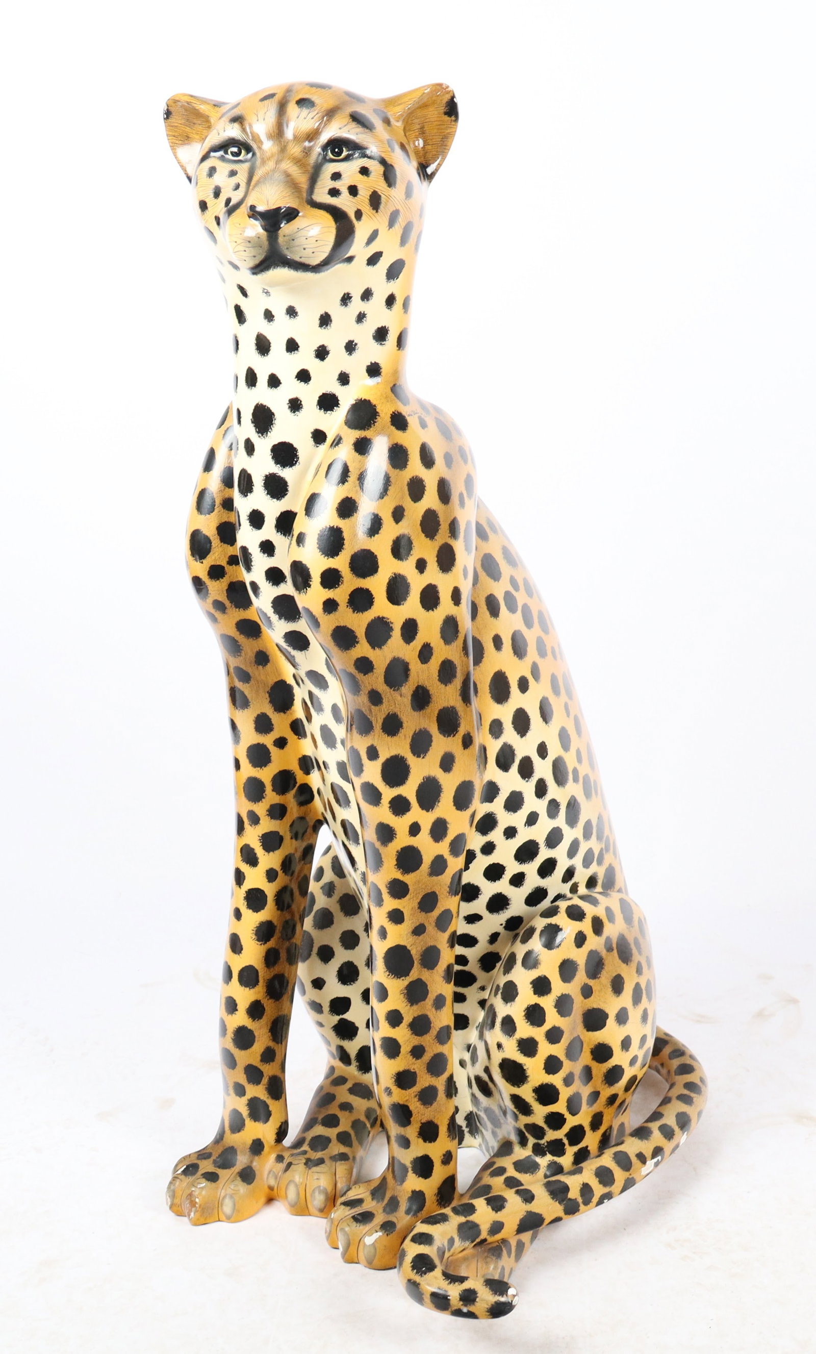 Carlos Alberto Papier Mache Life Size Cheetah: Carlos Alberto papier mache life size seated cheetah, signed and numbered Carlos Alberto 60/150. [47" H x 20" W x 24" D]. Overall condition is good, with loss to knuckles and minor scatter damaged.