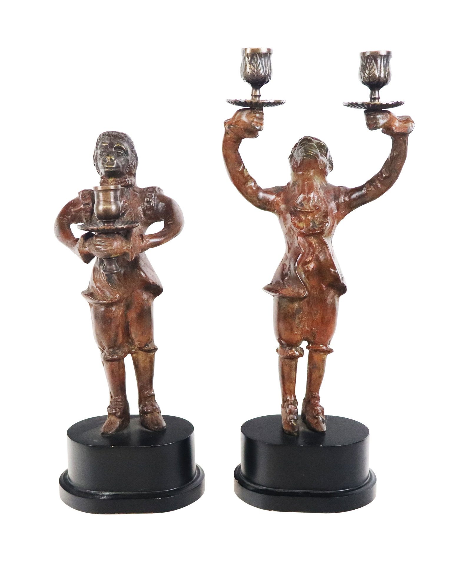 Companion Painted Metal Monkey Candlesticks, 2: Companion pair of painted metal whimsical monkey candlesticks, resting on oval metal bases. [Largest: 18" H x 7.5" W x 5" D]. Overall condition is good. From the esteemed collection of Neil Zukerman f