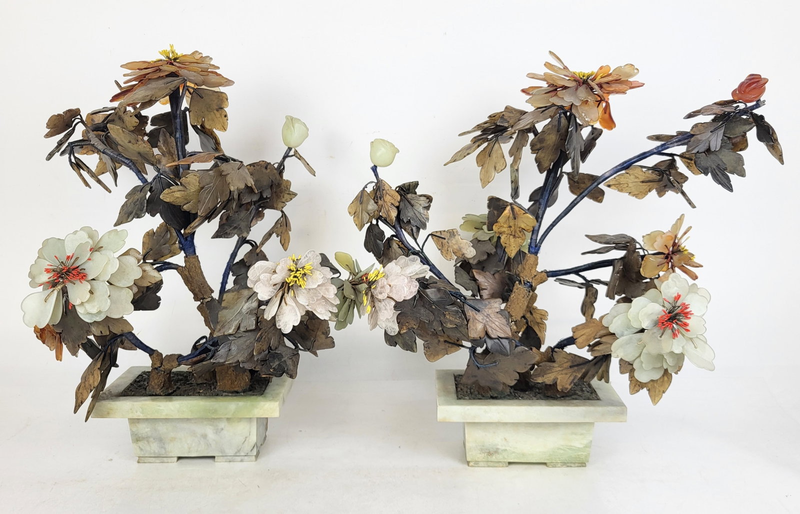 Pair of Chinese Hardstone Trees: Pair of Chinese hardstone trees, mid-20th century, with carved stone and plaster details at trunks. [19" H x 15" W x 10" D]. Condition is good with some minor losses and wear.