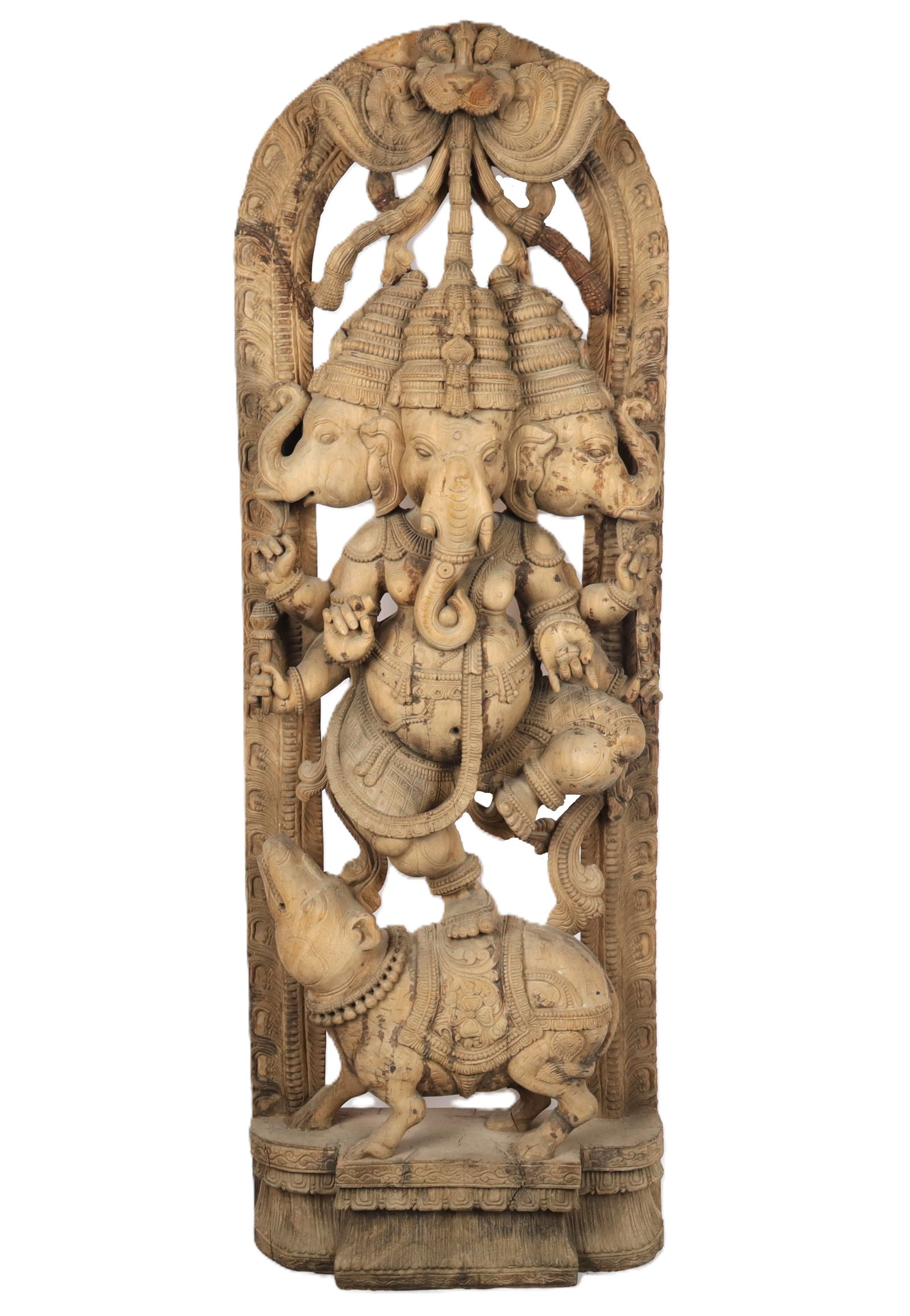 Carved Wood Tri-Mukha Ganesha: Carved wood tri-Mukha Ganesha, 20th century, depicting the deity dancing on a rat, with elaborate frame decoration. [72" H x 26" W x 10" D]. Condition is good with some areas of repair. From the estee