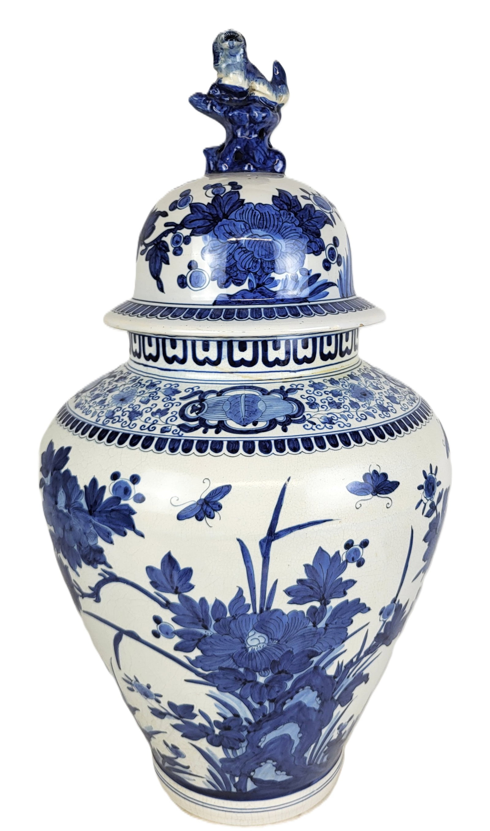 Delft Faience Porcelain Ginger Jar: Delft porcelain ginger jar, 20th century, with hand painted Chinoiserie decoration, and lion finial marked to base. [23" H x 13" Diameter]. Condition is good with crazing, previously drilled to base.