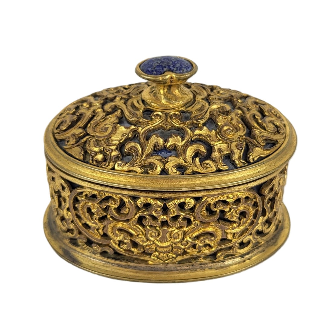 E.F. Caldwell & Co. Gilt Copper Box: E. F. Caldwell & Co. New York gilt copper box, early 20th century, with filagree decoration and lapis to finial, signed E.F. Caldwell & Co. New York to base. [2.5" H x 3" W x 2.5" D]. Condition is goo