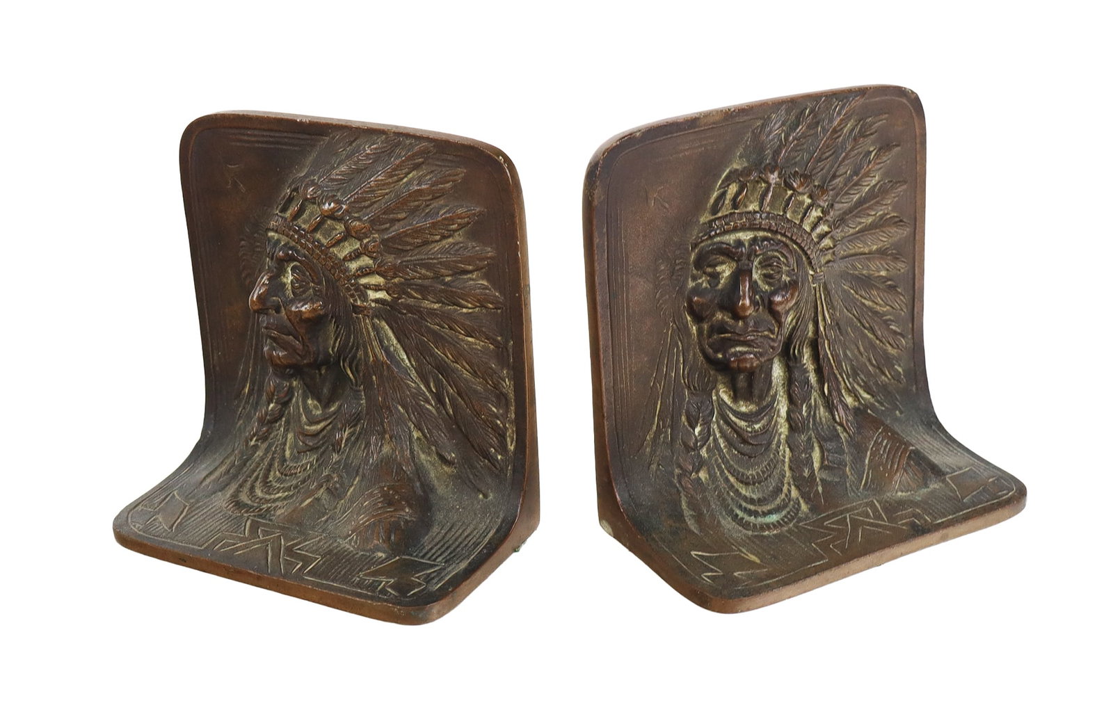 Pair of Native American Bronze Bookends: Pair of Native American bronze bookends depicting a three dimensional portrait of a powerful leader in a feathered headdress or warbonnet, mark to reverse "Solid Bronze". [4" H x 4.5" W 2.5" D]. Overa