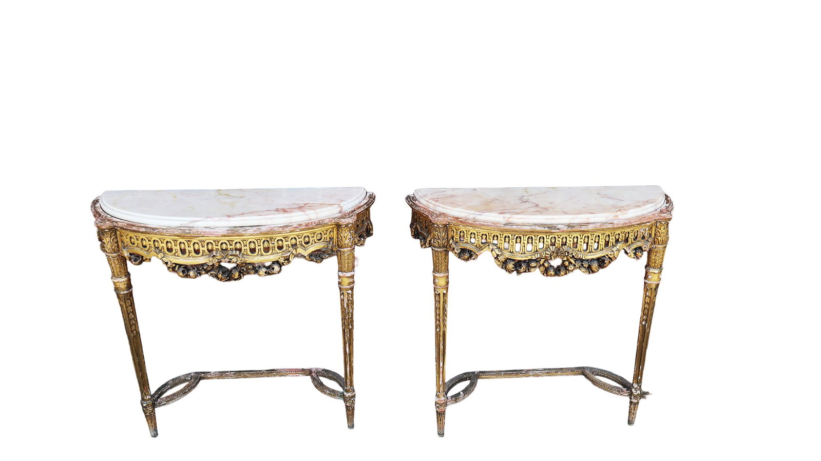 Pair of Louis XVI Carved & Gilt Demilune Consoles: Pair of Louis XVI carved and gilt demilune consoles, 19th/20th century, with marble tops and heavily carved frames. [30" H x 29" W x 9" D]. Condition is good with some minor surface wear.