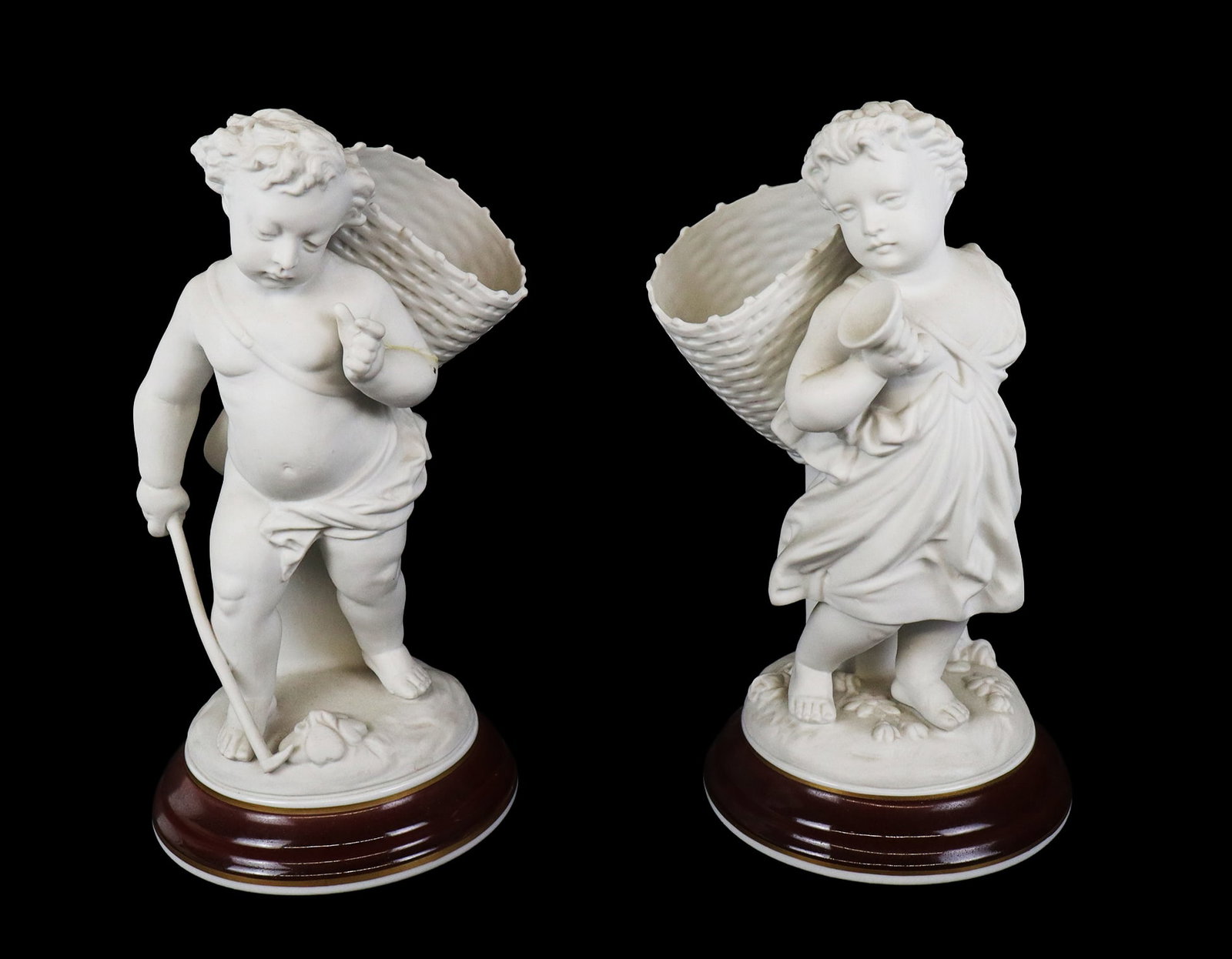 Pair of Parian Ware Figures: Pair of Parian ware figures of children with baskets on glazed bases, 20th century, marked to each at underside. [11" H x 5.5" Diameter]. Condition to one is good, break to lower of other and repair