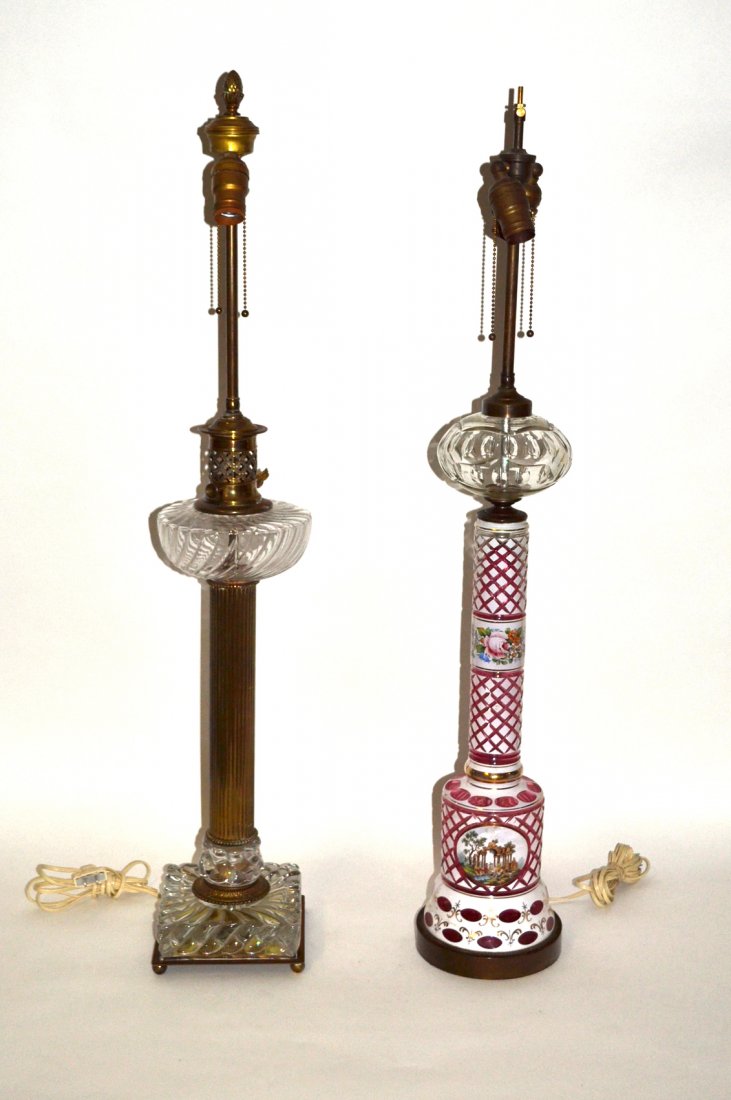 Two Vintage Electrified Column Lamps: Comprises: 1). Bohemian cased and cut white to pink lamp with gilt accents, reserve with figures at an ancient ruin, floral band and crystal top. [6 1/2" Dia. x 37" H]. 2). Bronze, brass and glass lam