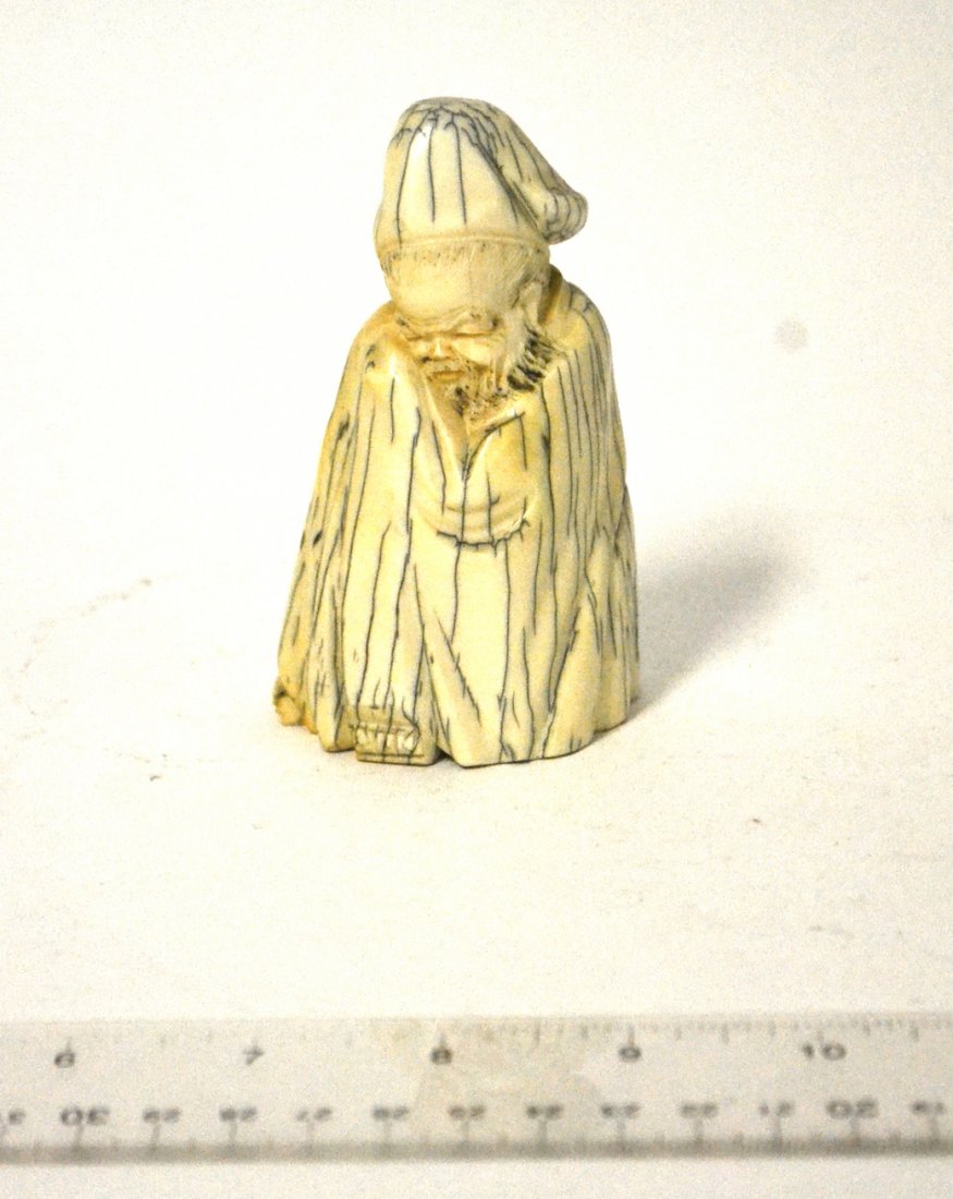 Chinese Carved Mammoth Tusk Figure: Depiction of a seated scholar at rest in a long robe and hat. [2 1/2" W x 2" D x 4 1/8" H]. Bears dark blue and grey veins throughout.