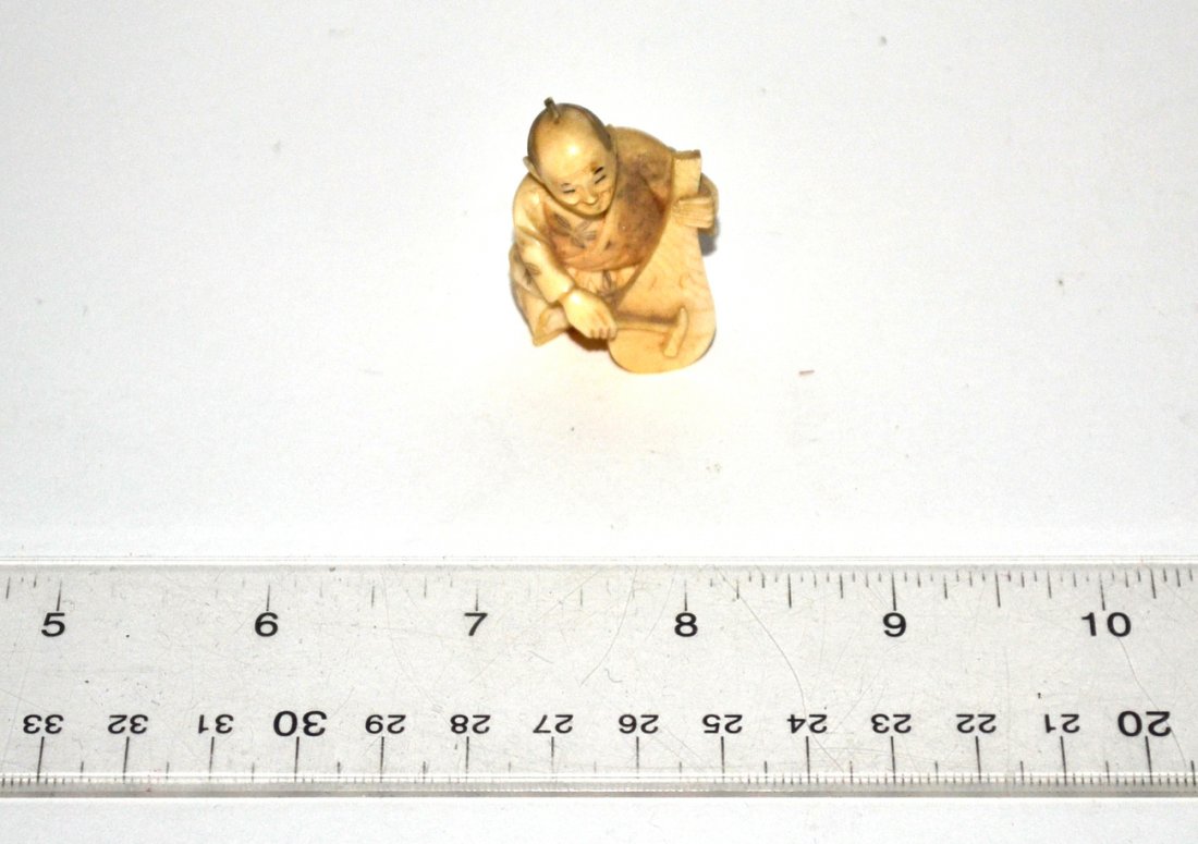 Ivory Netsuke: Ivory Netsuke, man with an instrument. In good condition.