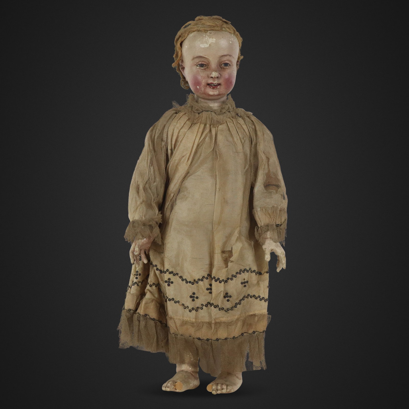 Carved and Painted Baby Doll: Carved and painted baby doll, 19th century, with carved and painted details and silk garments. [17" H x 7" W x 3" D]. Condition is good to fair with wear and losses including to toes.