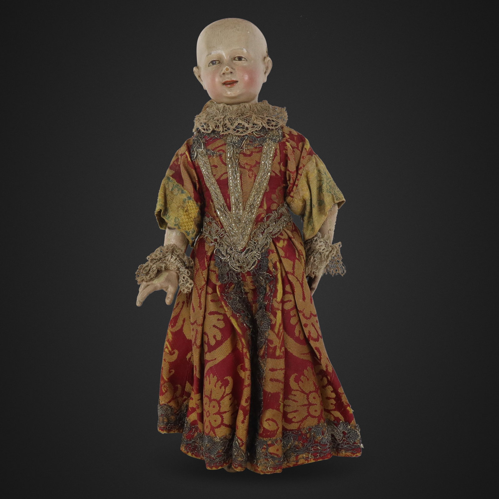 Carved and Painted Colonial Santo Doll: Carved and painted Colonial Santo doll, Spanish, 19th century, with brocade and gilt embroidered robs and holes for mounting. [17" H x 7" W x 3.5" D]. Condition is good to fair with wear and losses in