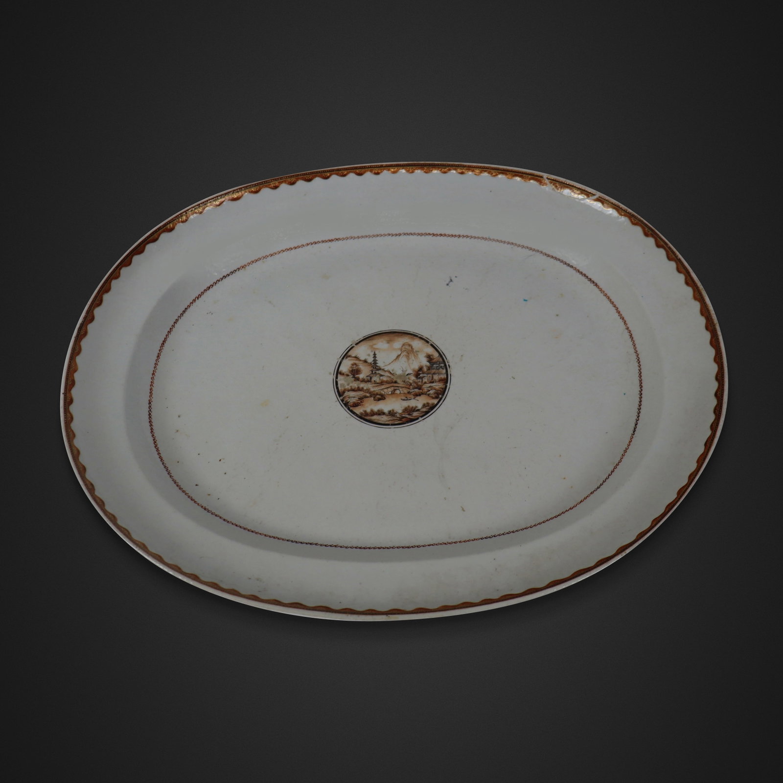 Chinese Export Serving Platter: Chinese export serving platter, Qing Dynasty, early 19th century, with hand-painted landscape design to center and decoration to rim, unmarked. [15" H x 18" W]. Condition is good with some minor wear 