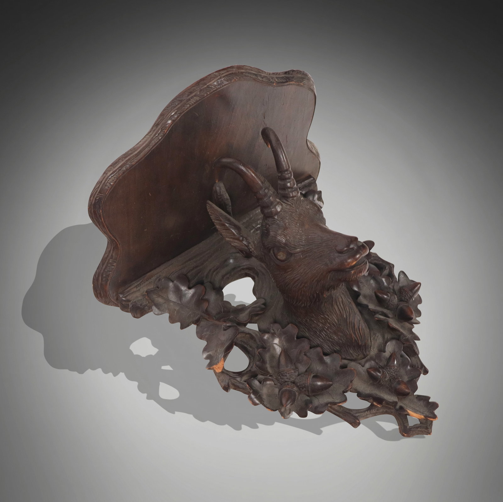 Black Forest Carved Bracket Applique with Goat: Black Forest carved bracket applique, German, 19th century, with a kid or young goat surrounded by oak leaves and acorns. [11.5" H x 11.25" W x 8.25" D]. Condition is good to fair with some losses to 