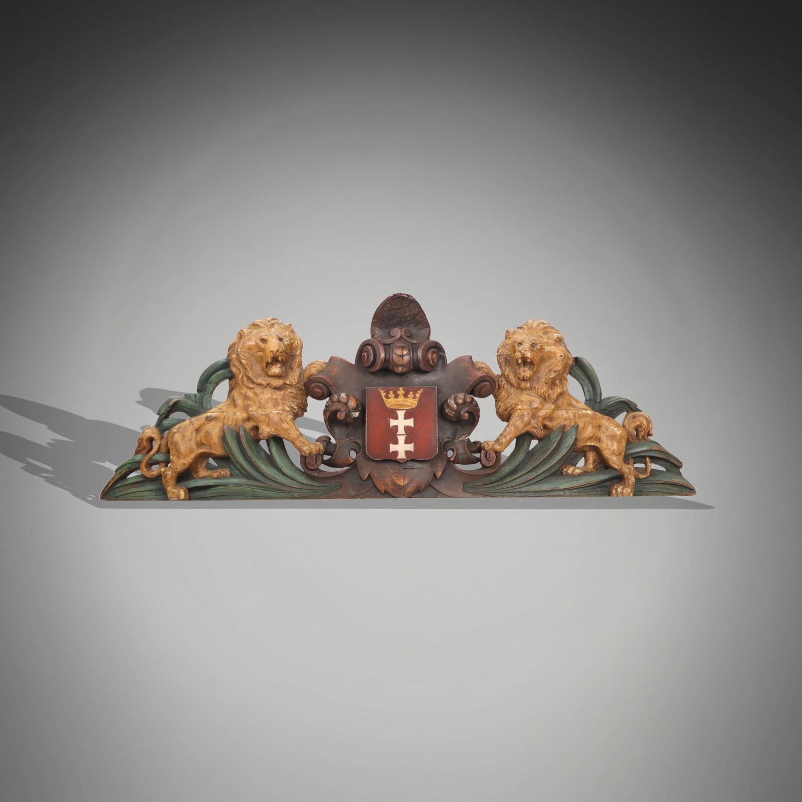 Large Carved Wood Heraldic Applique: Carved wood applique or fragment, 19th century, with two lions flanking a crest and hand-painted details. [29" H x 81" W x 9" D]. Condition is good with age-commensurate surface wear and some cracking