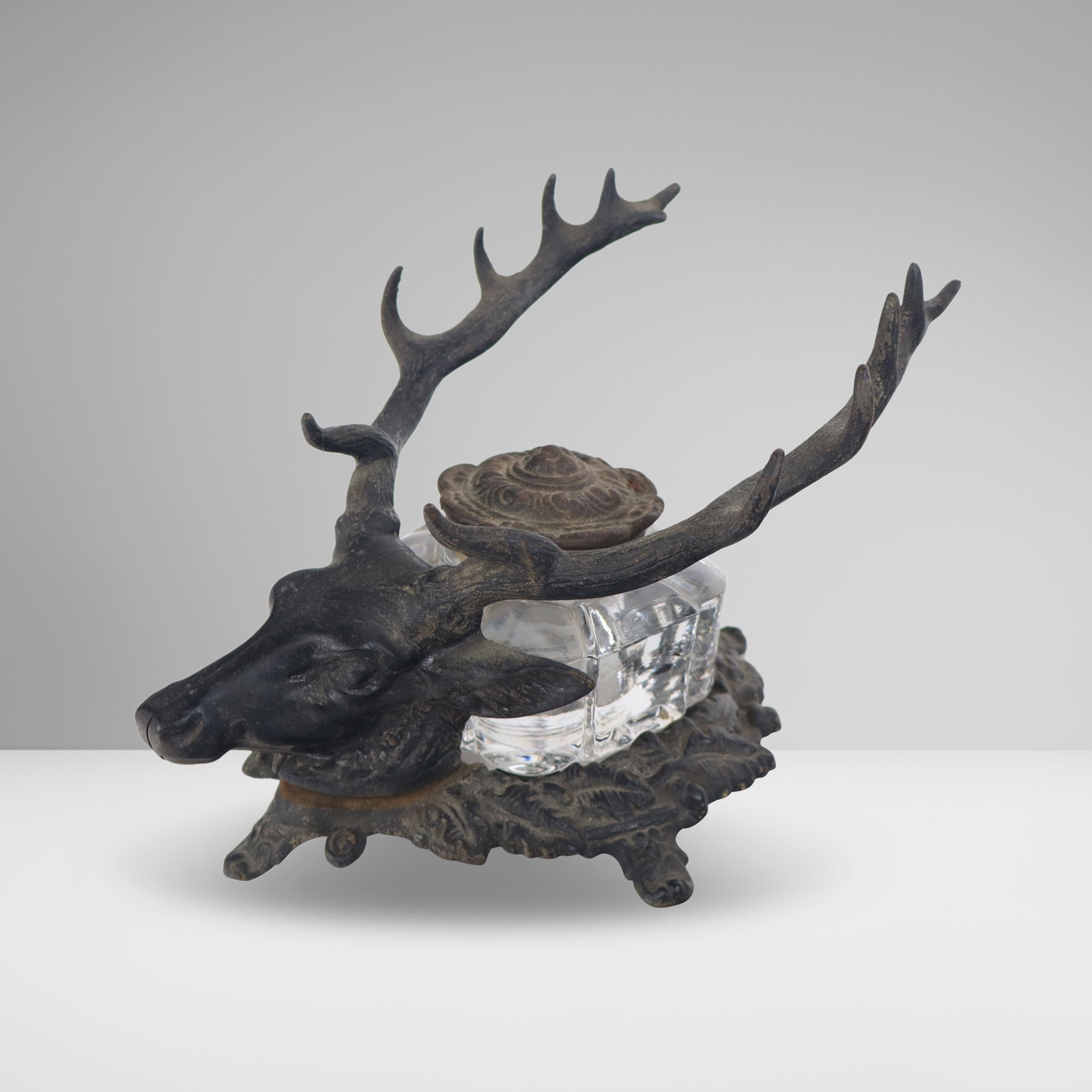 Cast Iron Stag Form Inkwell: Cast iron stag form inkwell, 19th century, with a glass insert, unmarked. [4.5" H x 6" W x 7" D]. Condition is good with some areas of rust, one screw missing from mount at head.