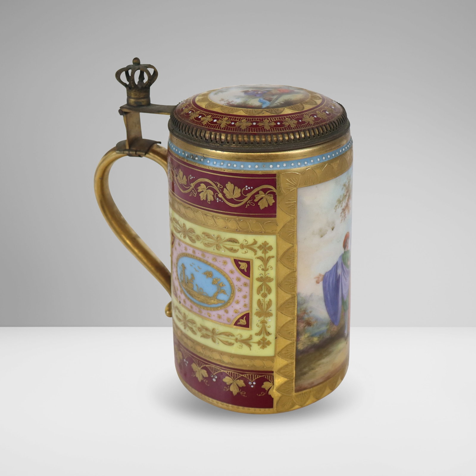 Royal Vienna Porcelain Tankard: Royal Vienna porcelain tankard, 20th century, with hand-painted and jeweled decoration and a gilt mounted handle with crown, with marks to base. [6.5" H x 6" W x 4.5" D]. Condition is good with some