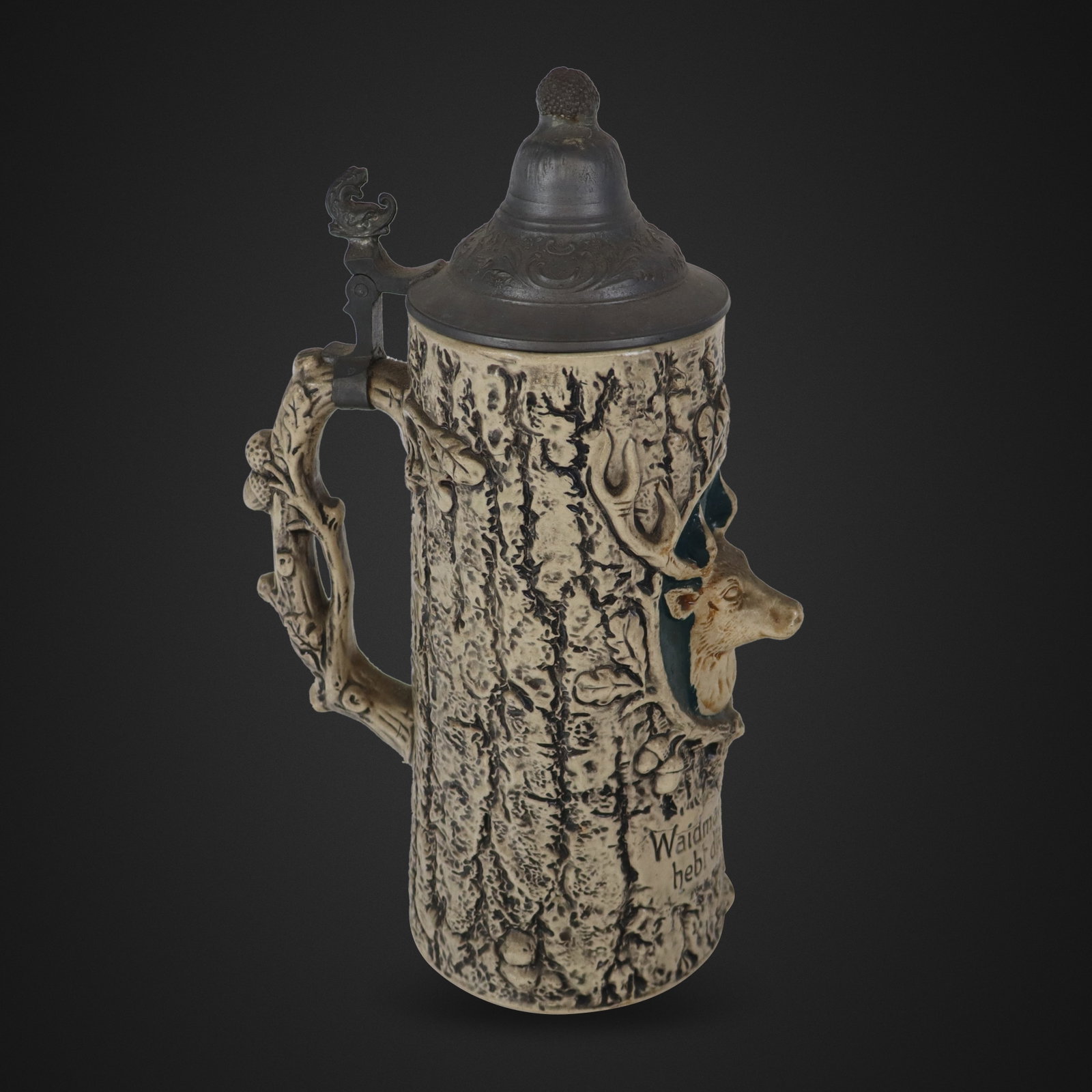 German Porcelain Beer Stein with Deer: German porcelain beer stein, 20th century, with a stag mount to one side over an inscription, and mounted in pewter, marked Germany to base. [12" H x 9" x 4.5" D]. Condition is good with some minor