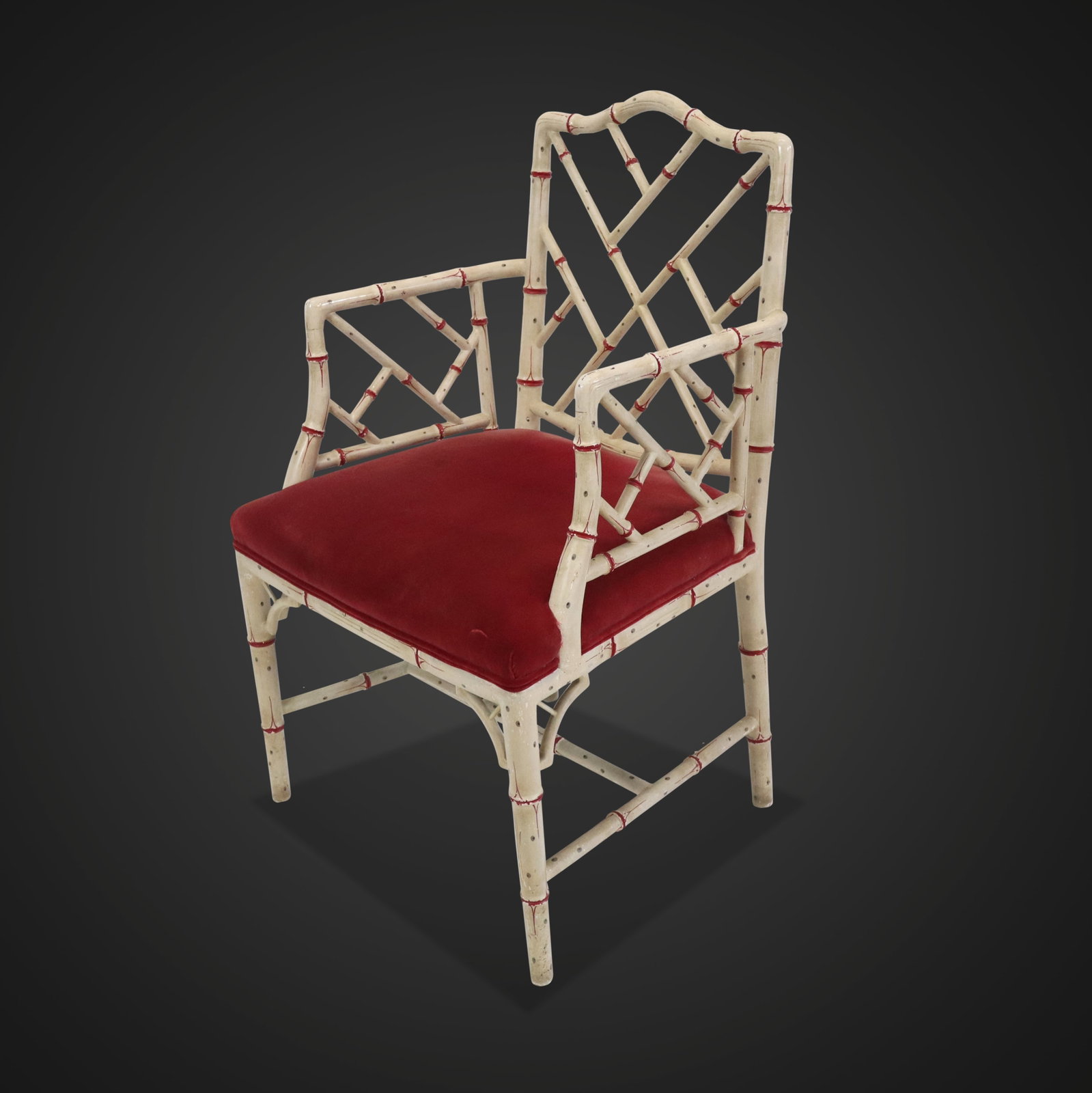 White Painted Faux Bamboo Armchair: White painted faux bamboo chair, circa 1960s, with red accents and red velvet upholstered seat. [37" H x 23" W x 19" D; seat height: 19"]. Condition is good with surface wear and fading to seat.