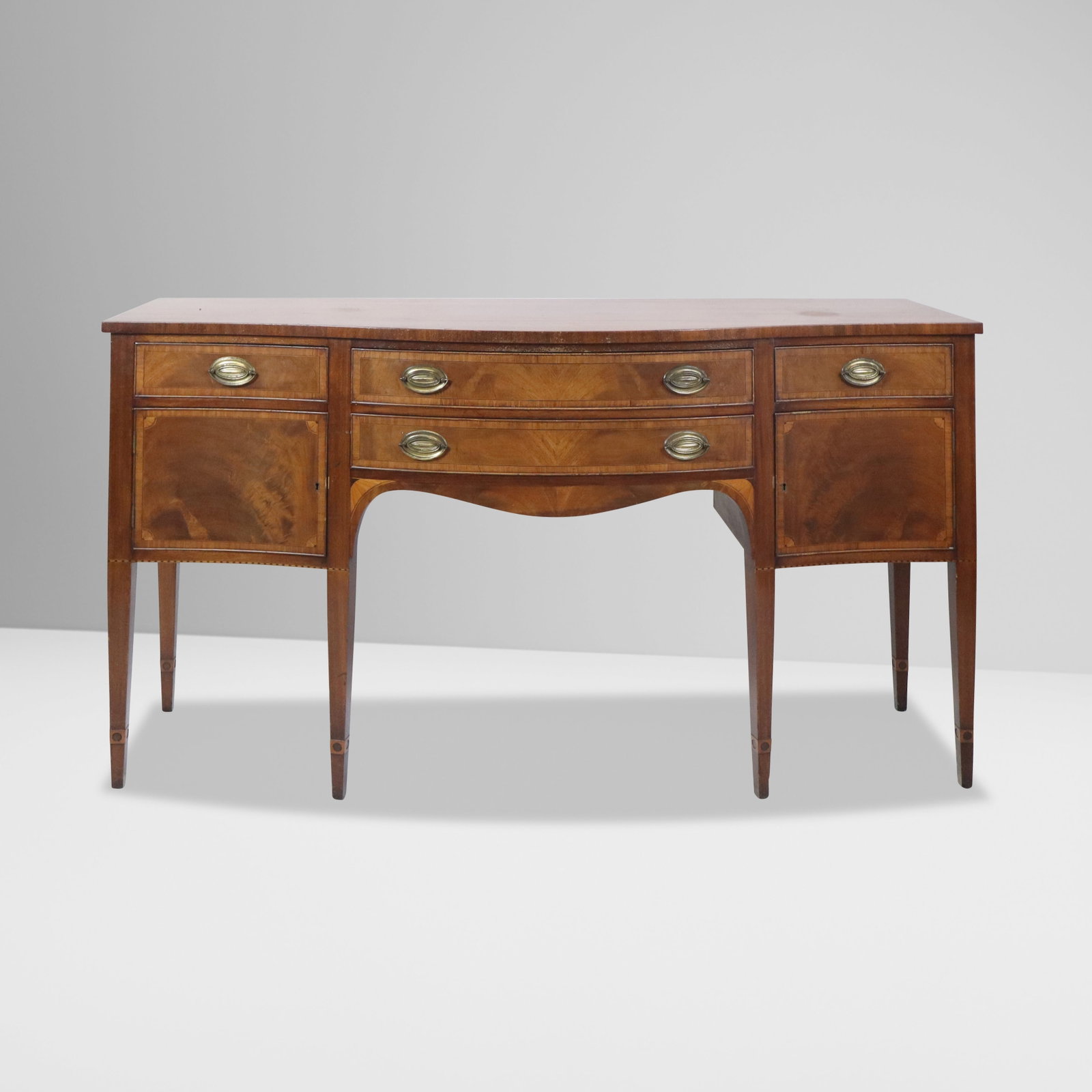 Federal Mahogany Sideboard Credenza: Federal mahogany sideboard credenza, 20th century, with two silverware and another drawers to upper over a long drawer flanked by two cabinets, on tapered legs. [38" H x 71" W x 22.5" D]. Condition is