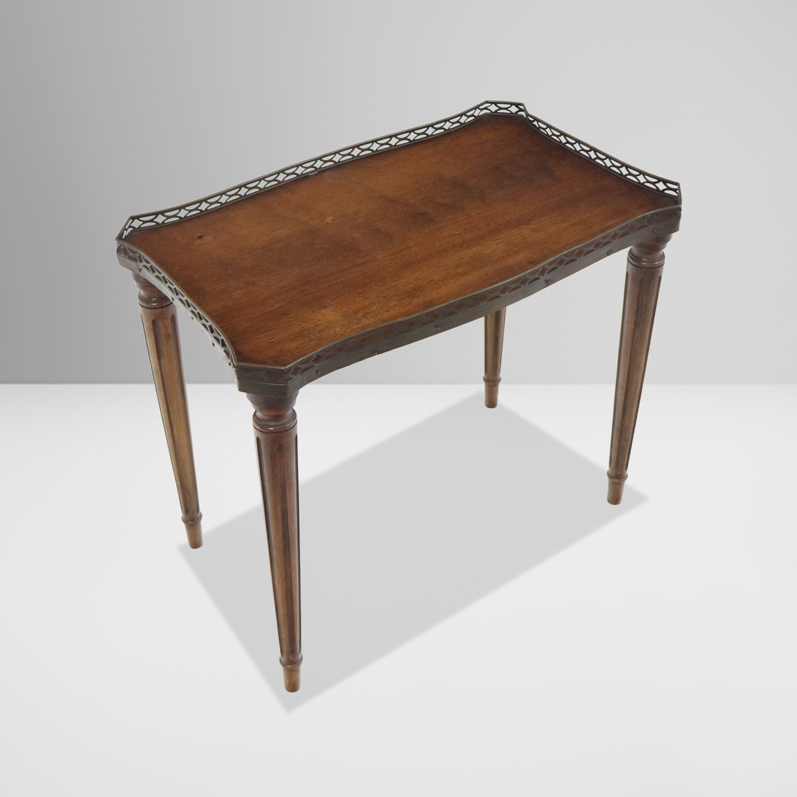 Louis XVI Mahogany Table: Louis XVI mahogany table, 20th century, with a galleried top and tapered legs. [18.5" H x 22" W x 13.5" D]. Condition is good to fair with some disconnection at joints and warp to galleried top.