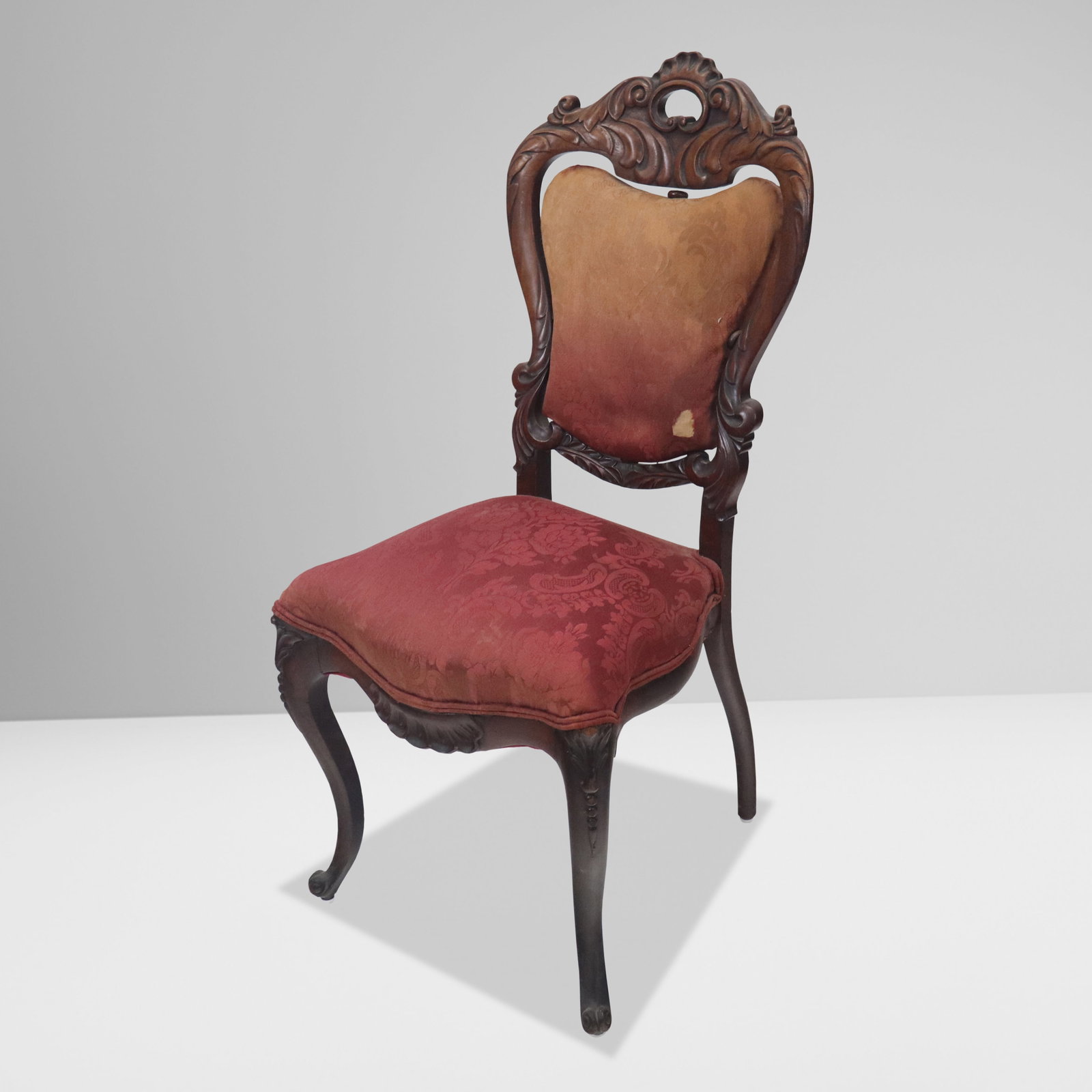 Victorian Carved and Upholstered Side Chair: Victorian carved and upholstered side chair, American, 19th century, with carved backrest and legs, and floral upholstery. [38" H x 18" W x 20" D; seat height: 18"]. Condition is good with fading and 