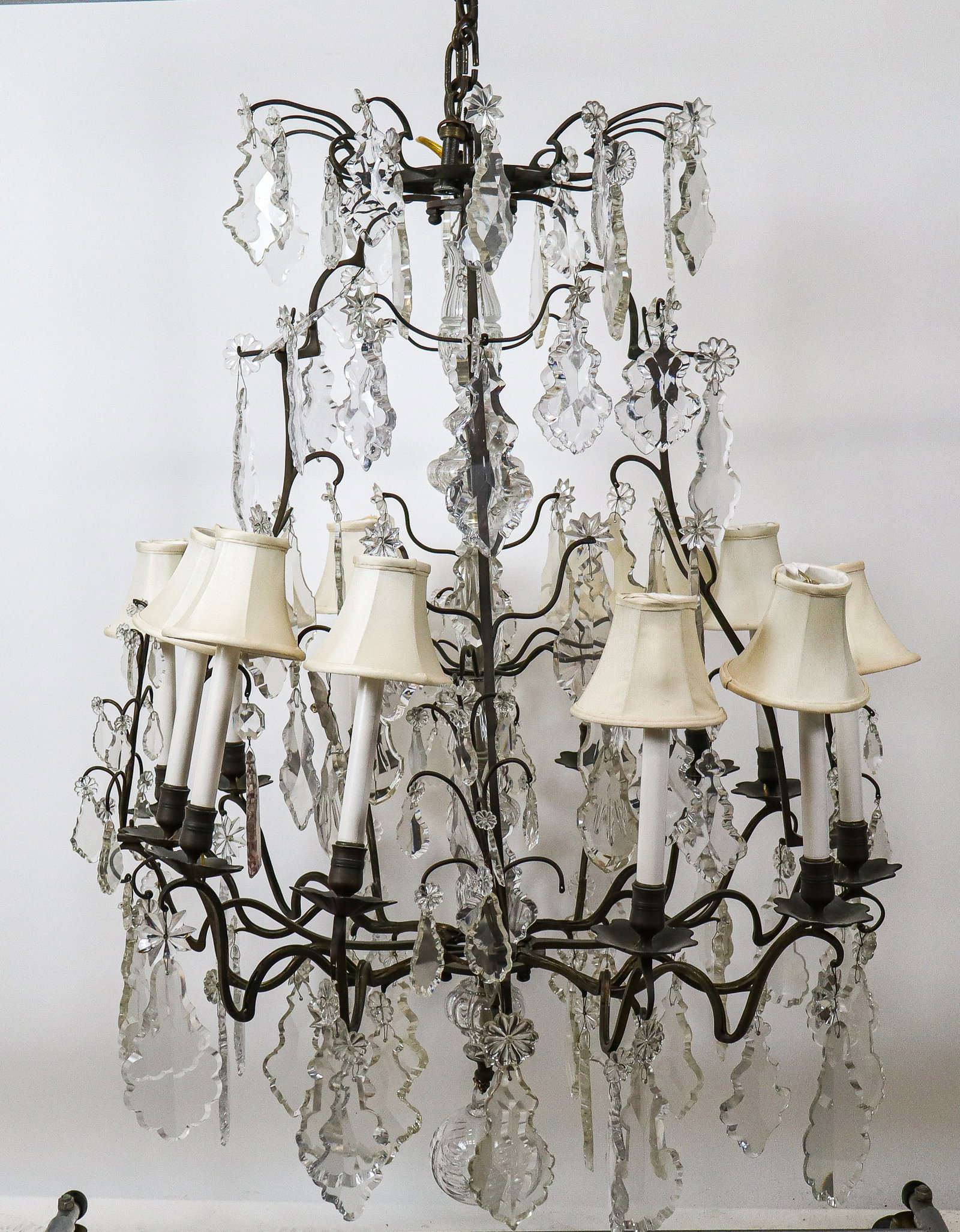 Regency 12 Arm Bronze Chandelier: Regency 12 arm bronze chandelier, multiple tiers of arms with small and large crystals, 12 arms and lights in 4 sets of 3, the center post in cut glass fonts, with a spear point bottom. [46" x 36" dia