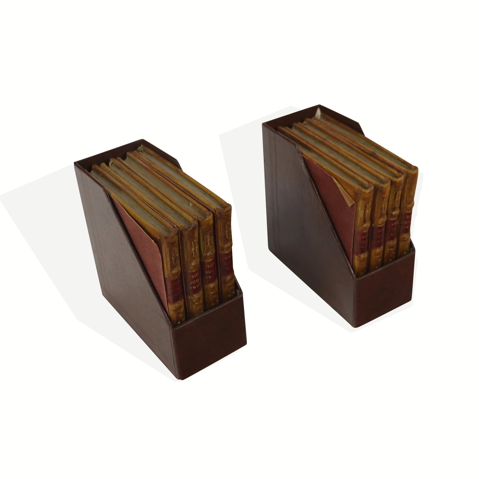 Two Sets of Four Handmade Book Form Coasters: Two sets of four book form coasters from The Original Bookworks, England, 21st century, with gilt pages and felted bottoms, and in two cases. [Each coaster: 0.5" H x 4" Square]. Condition is good with