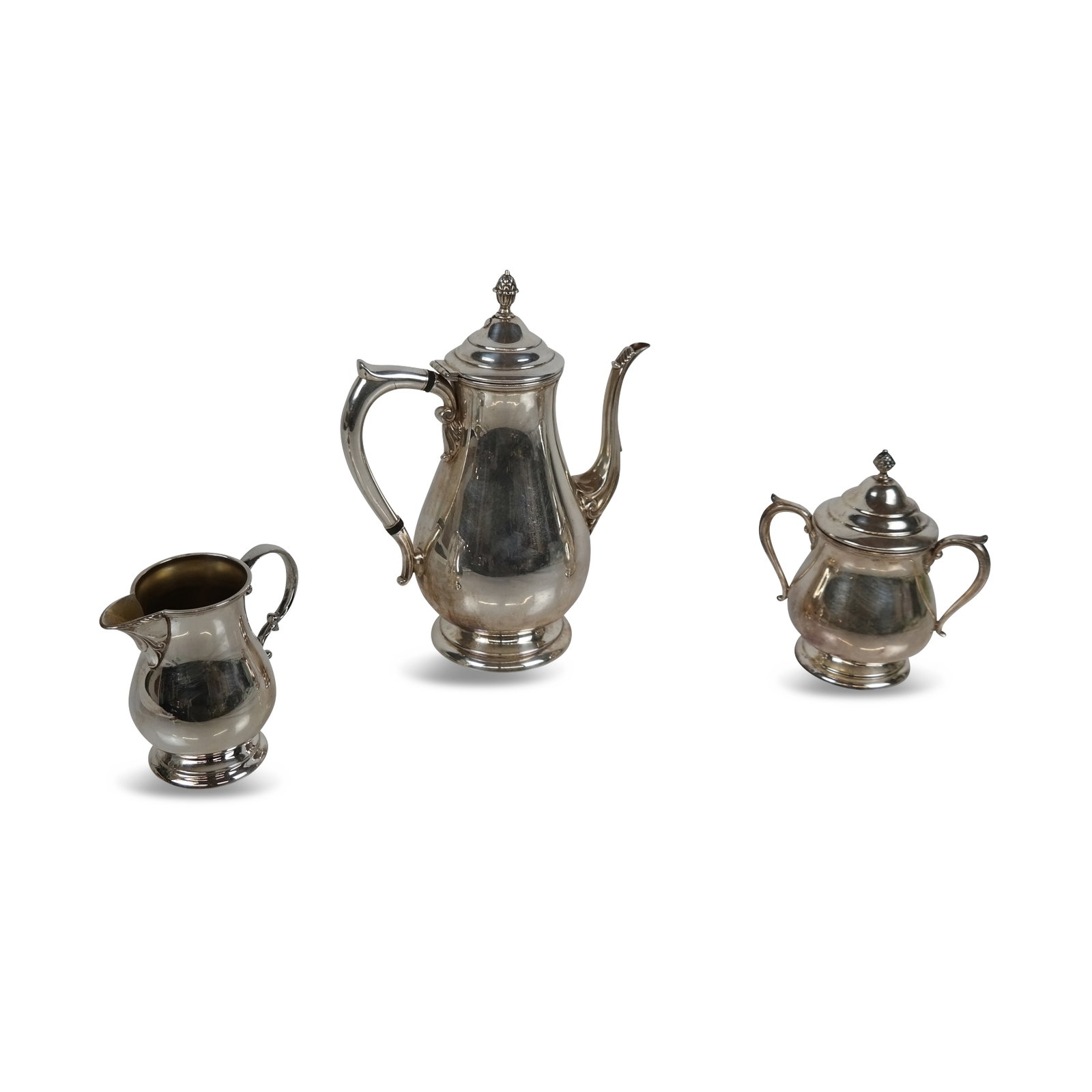Benedict Manufacturing Co. Silver Plate Coffee Set: Benedict Manufacturing Co. silver plate 3 piece coffee set, comprising coffee pot, creamer and covered sugar, marks to base. [10.5" H x 8.5" W x 5" D]. Overall condition is good.