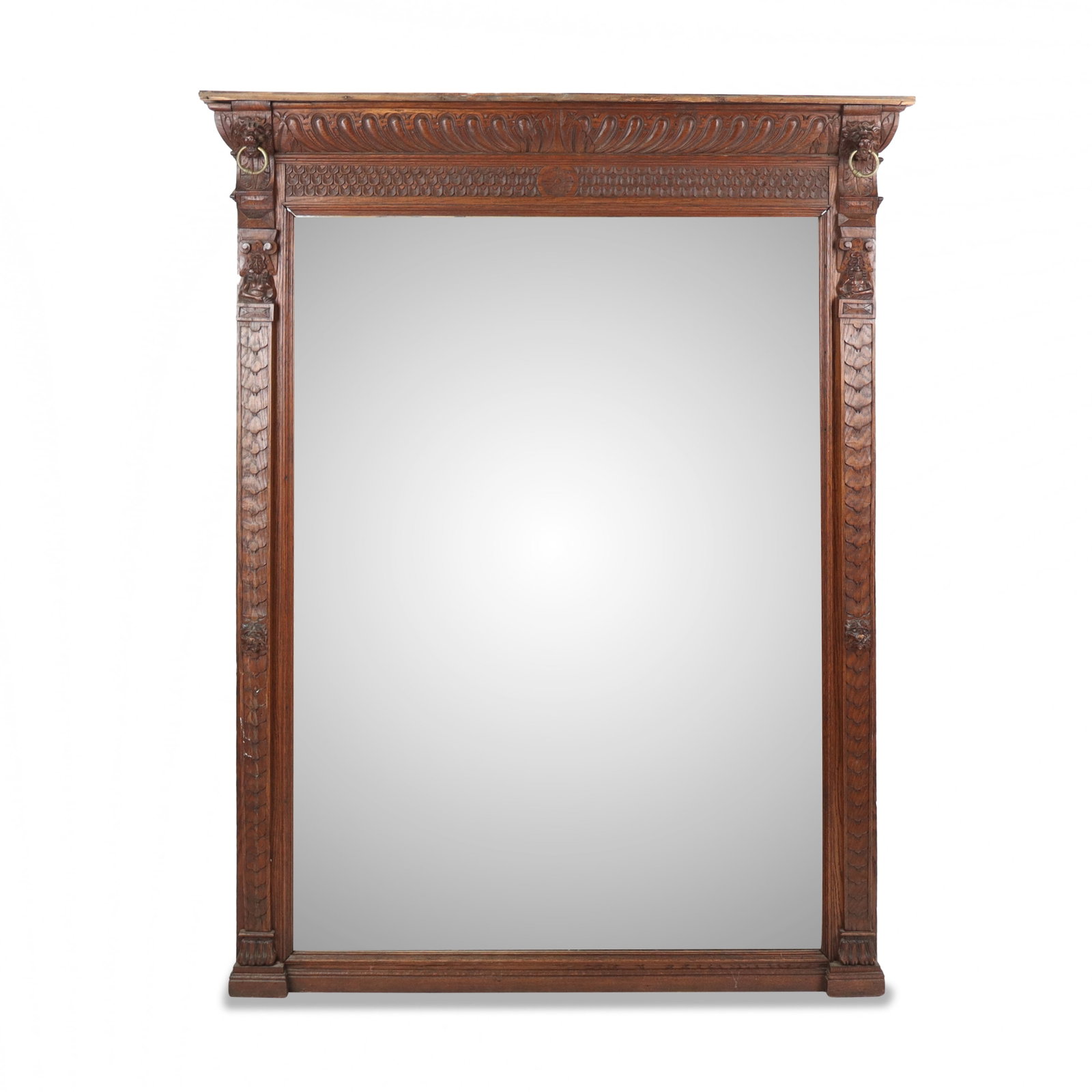 Renaissance Revival Carved Wood Mirror: Renaissance Revival carved wood mirror, late 19th century, with carving to upper flanked by two lion heads with brass rings, and further masks to frame at sides. [73" H x 56" W]. Condition is good wit
