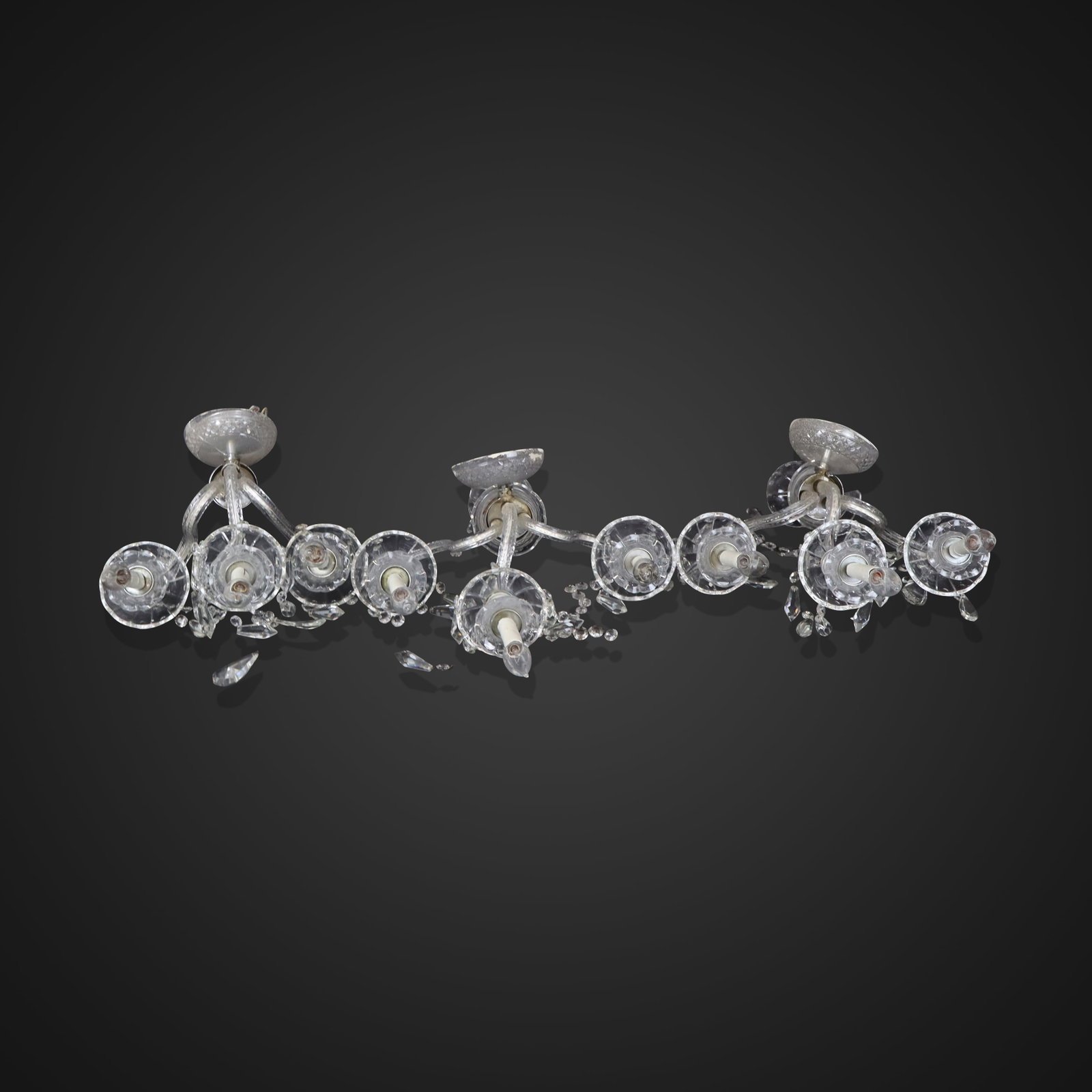 Three Cut Crystal Sconces: Three cut crystal sconces, 20th century, with three girandole arms and three lights to each and faceted glass lustres. [18" H x 14" W x 10" D]. Condition is fair to poor with heavy losses and breaks, 