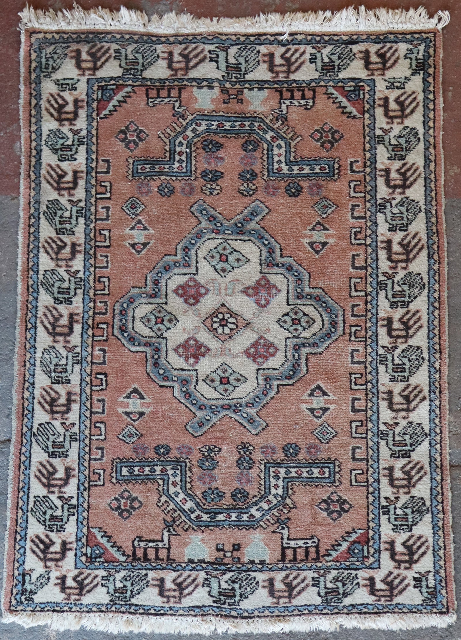 Turkish Wool Rug: Turkish wool rug, 20th century, hand-knotted, with medallion and bird detail, fringe to two ends. [43" W x 62" L]. Condition is fair with wear and fading.