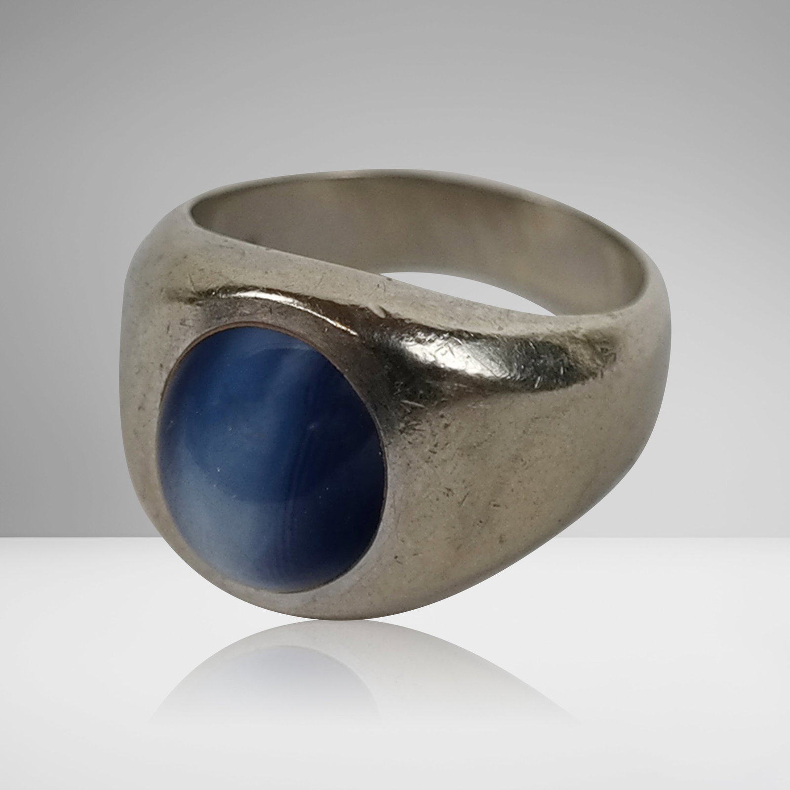White Gold and Synthetic Star Sapphire Ring: 14K White gold and synthetic star sapphire gypsy ring, marked 14K on interior shank. [7.5 dwt., Size: 6.5]. Overall condition is good, signs of normal wear.
