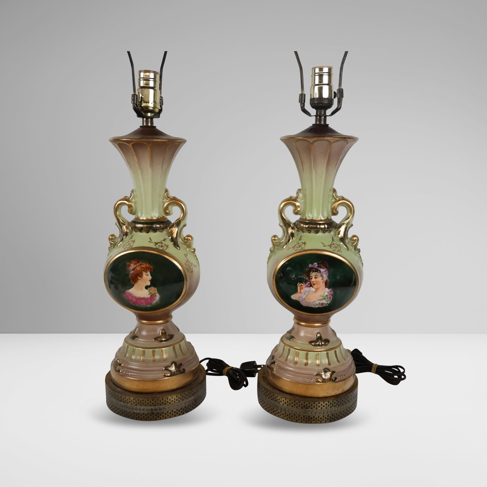 Pair of Painted Porcelain Lamps: Pair of painted porcelain lamps, mid-20th century, with gilt metal mounts and hand-painted portrait cartouches. [To lip: 16.5" H x 6" Diameter]. Condition is poor with losses to decoration and loose a