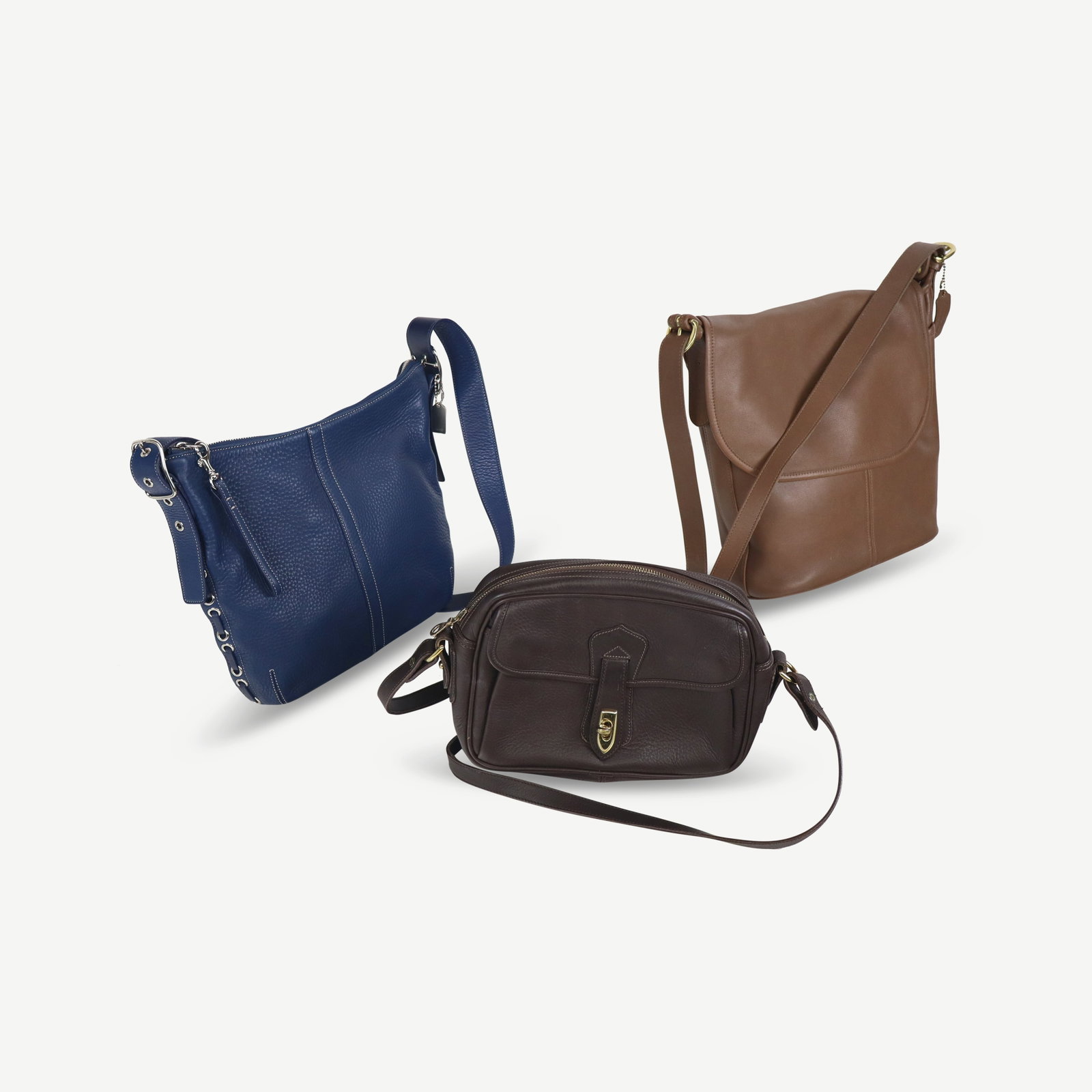 Two Coach and a Dooney & Bourke Handbags: Three handbags or pocketbooks comprising a Coach blue leather handbag with grommet decoration, a Coach bucket bag with flap closure, and a Dooney and Bourke handbag, all marked. [Coach bucket bag; les