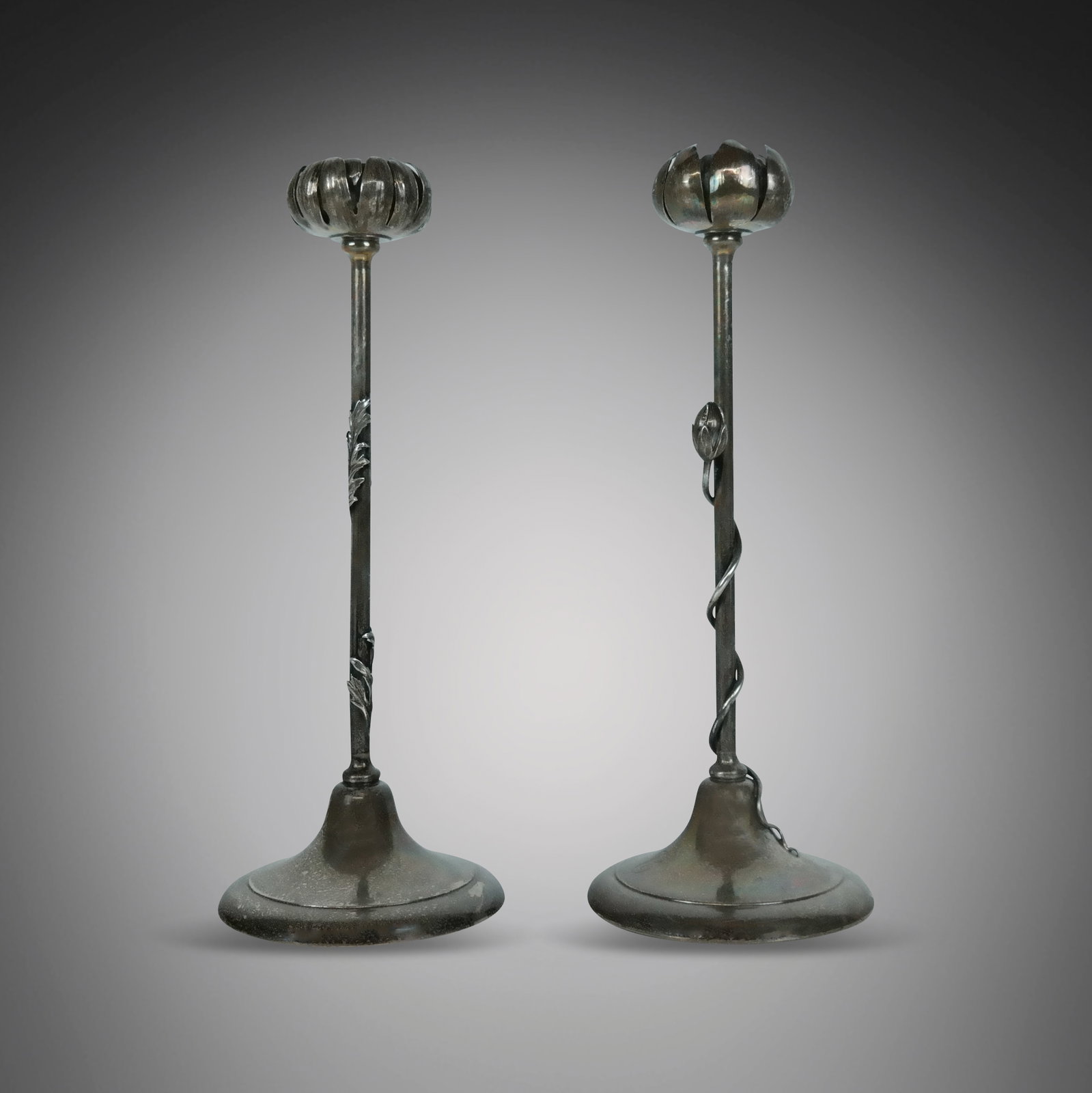 Two Aesthetic Movement Silver Flower Candlesticks: Two Aesthetic Movement sterling silver monogrammed flower candlesticks, weighted, each modeled as a blooming flower head on set with flower bud and tendrils, the other with foliage10, marks to base. [