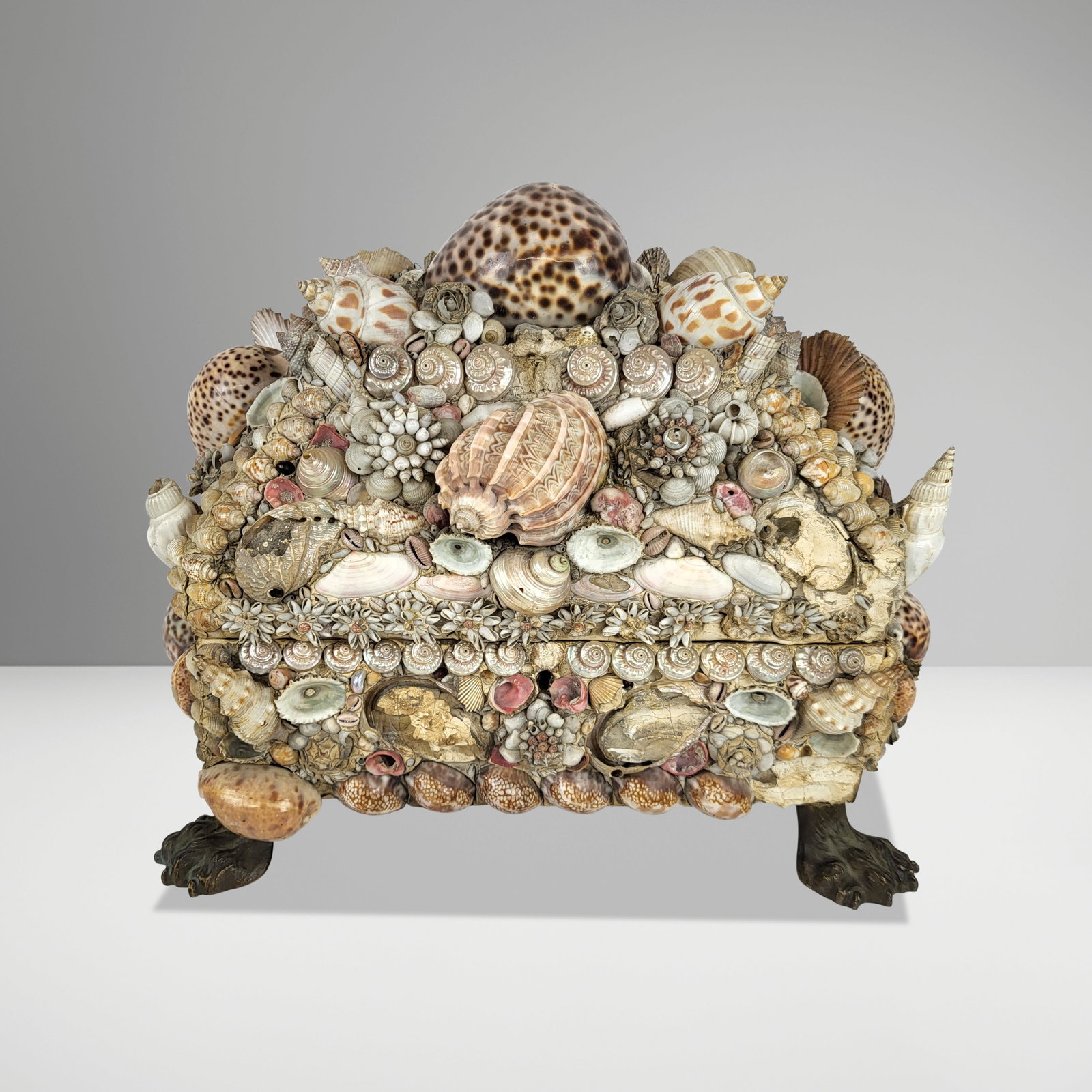 Folk Art Shell Decorated Box: Folk Art shell decorated box, American, early 20th century, with elaborated shell decoration and claw feet. [11.5" H x 13" W x 9.5" D]. Condition is good to fair with scattered minor breaks and