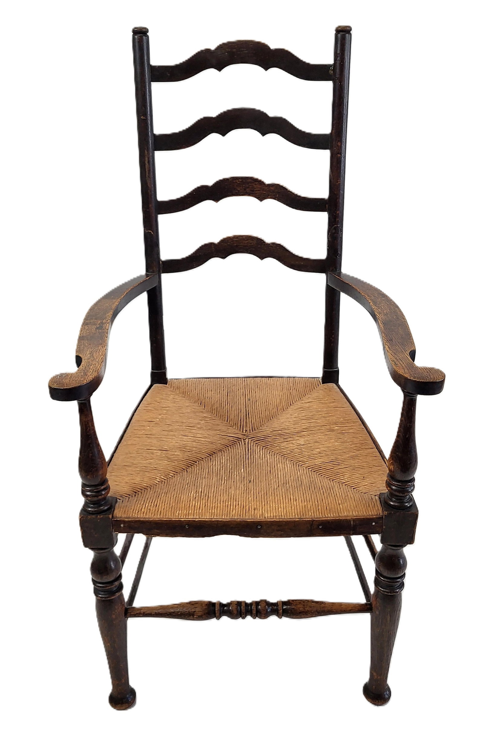 Antique American Oak Colonial Arm Chair: Antique American oak colonial arm chair, 19th century, with ladder back, wide arms turned posts on a rush seat. [45" H x 23" W x 22" D]. Chips and wear, ladder back has been broken and repaired.