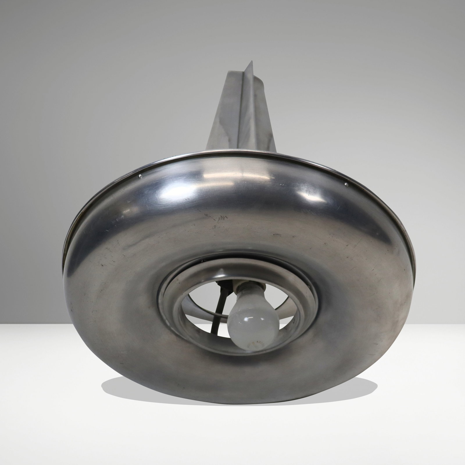 Art Deco Spaceship Form Fixture: Art Deco spaceship form fixture, mid 20th century, of brushed metal round base and rocket form post. Missing round glass shade. [24" H x 17" diameter]. Fair condition as shown, missing glass shade.