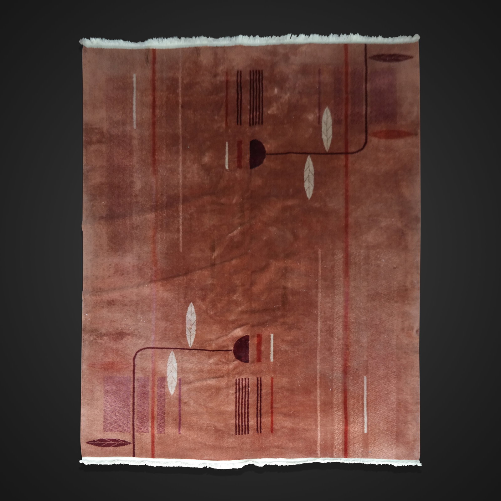 Art Deco Machine Made Carpet: Art deco machine made carpet - 5' 10" x 8' 6", American late 20th century, lines and leaves, in rust / pale orange colors. By Wilton rug company. Some matting, age rips, small spots, and losses.
