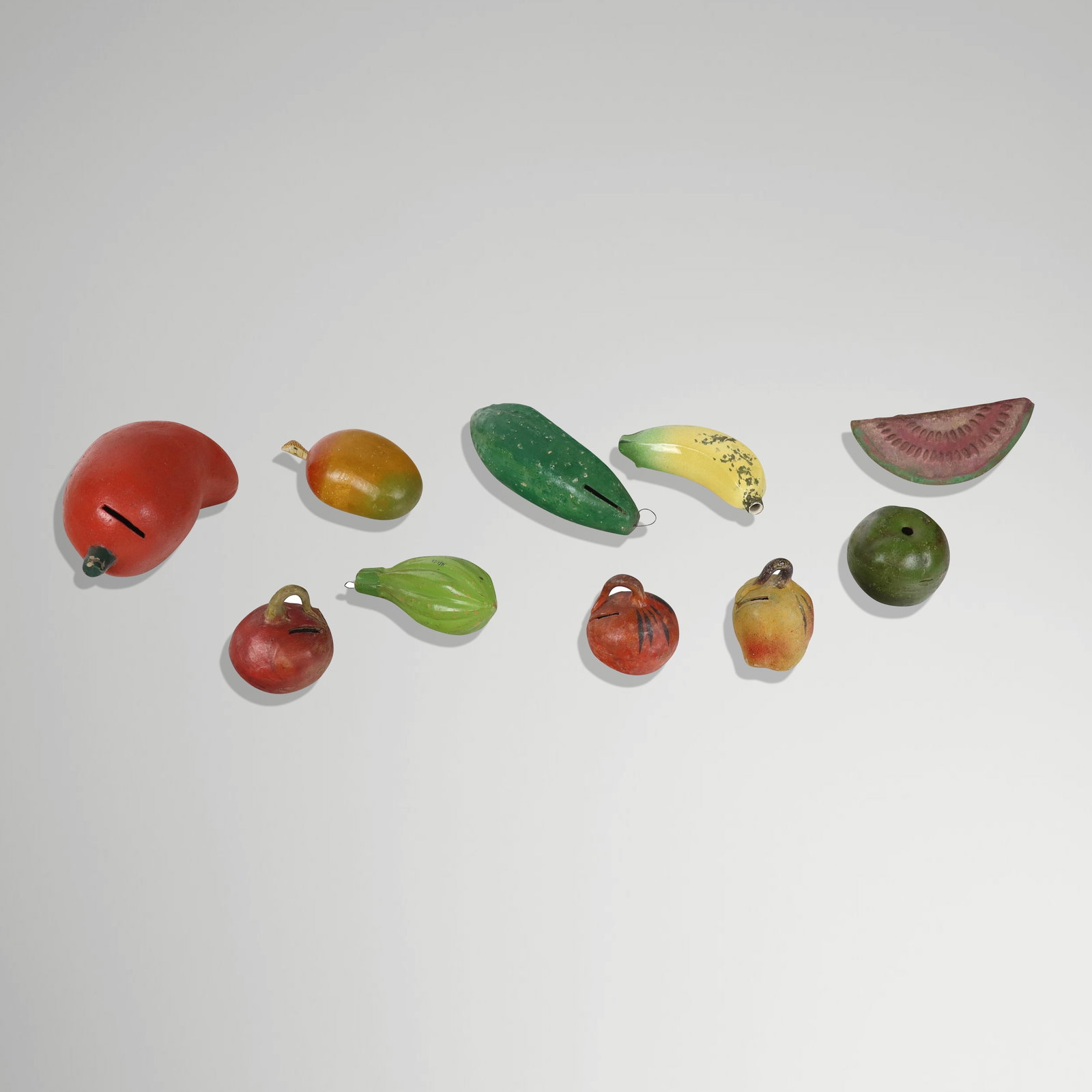 10 Mexican Ceramic Fruit & Vegetable Form Articles: Assorted Mexican fruit and vegetable form ceramic articles, 20th century, comprising coin banks including one in the form of a chilly pepper, a cocoa pod, four apples, a gourd, and a slice of watermel