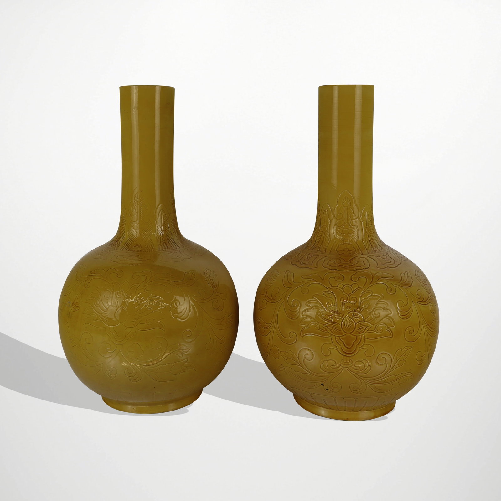 Pair of Chinese Yellow Glazed Vases: Pair of Chinese yellow glazed vases, 20th/21st century, with impressed floral design, unmarked. [17.5" H x 11" Diameter]. Condition is good to fair, one with loss to base.