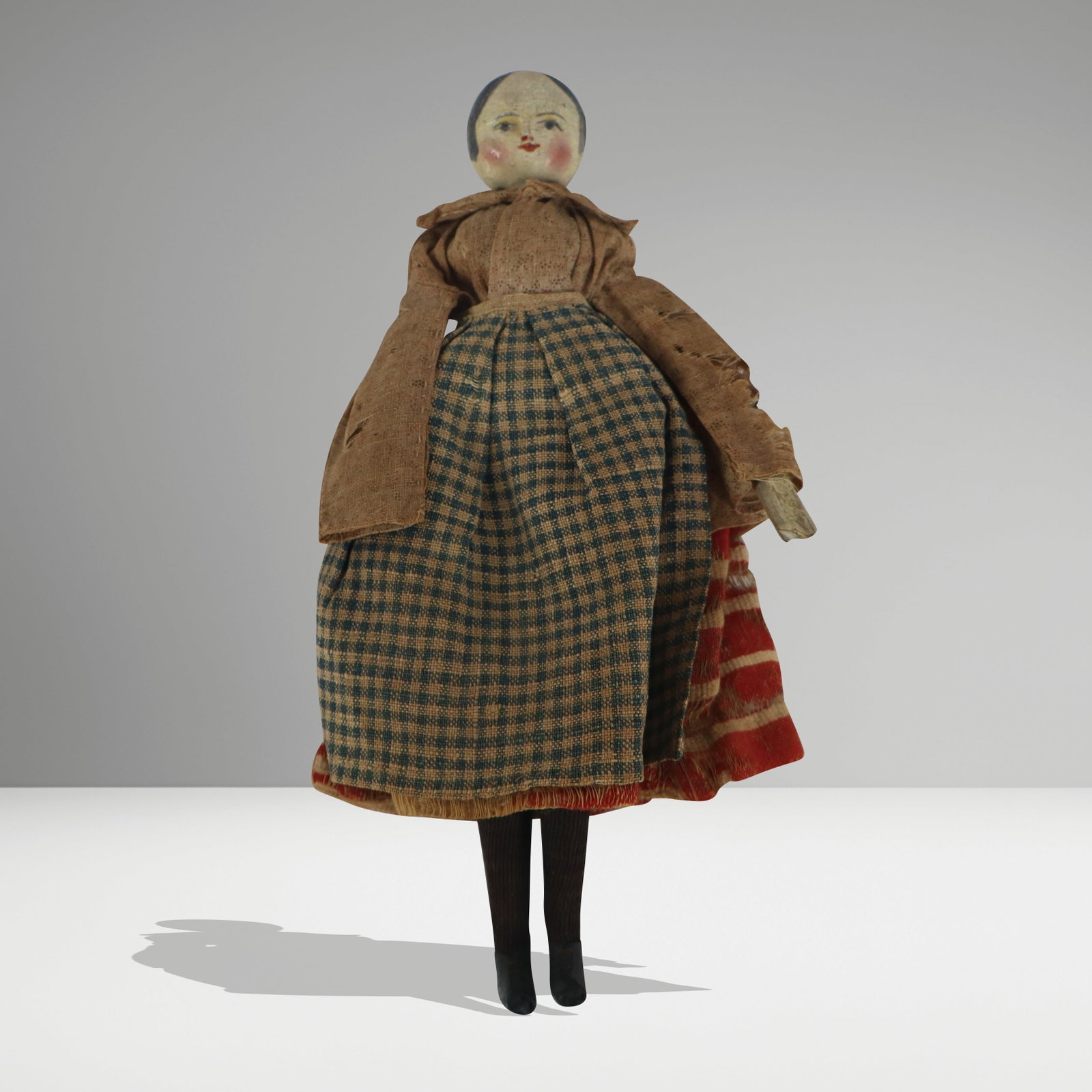 Painted and Reticulated Wood Doll: Painted and reticulated wood doll, United States, 19th century, likely Folk Art, with hand-painted details to face, and hand-stitched garments. [9" H x 5" W x 1.5" D]. Condition is good with craquelur
