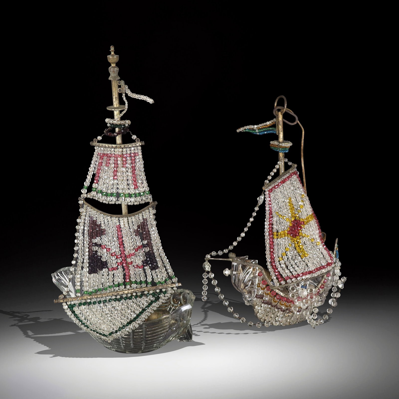 Two beadwork and glass hanging lights, 20th century, in the form of ships, with brass frames.: Two beadwork and glass hanging lights, 20th century, in the form of ships, with brass frames. [Taller: 22" H x 11" W x 6" D]. Condition to each is good with normal wear including some areas where
