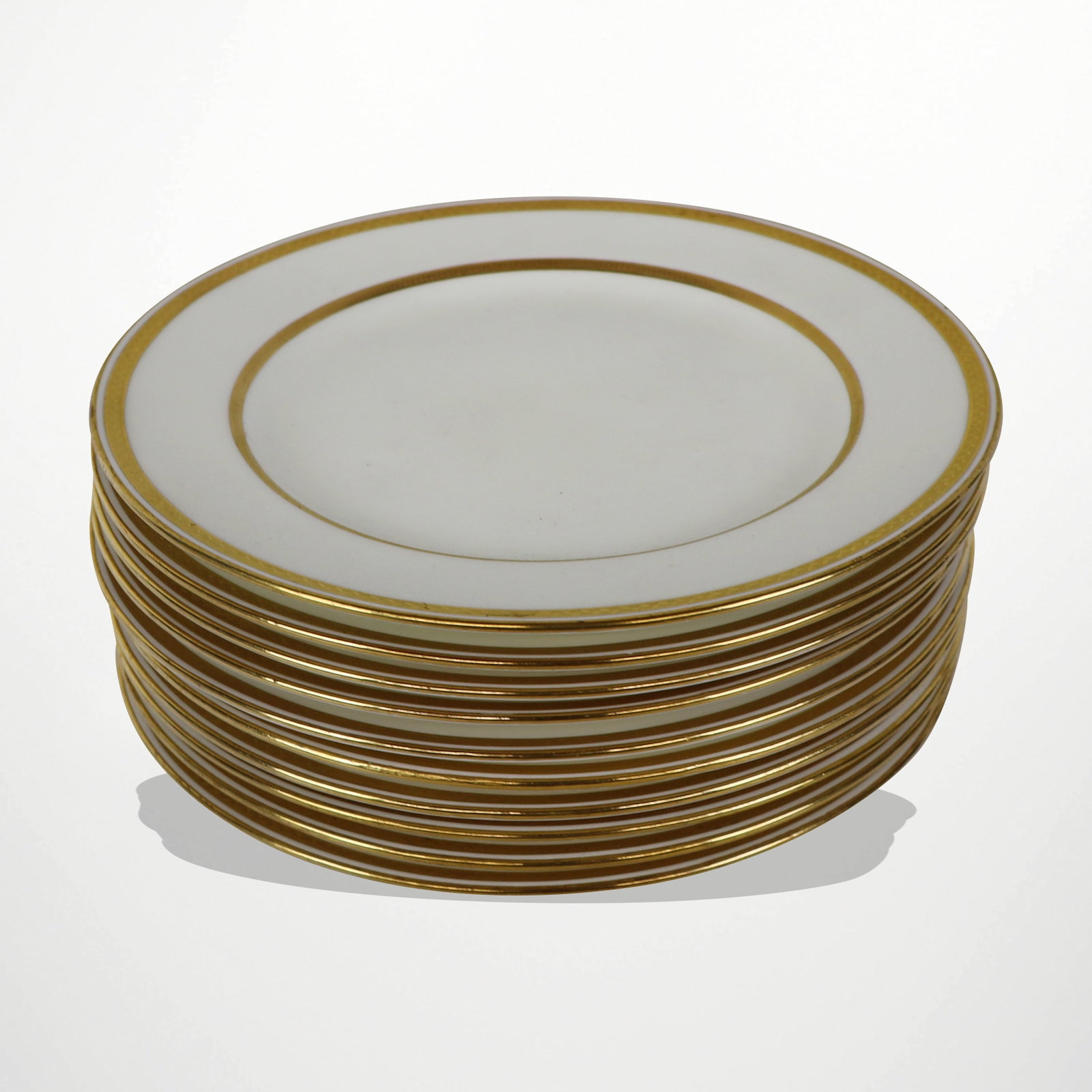Mintons for Tiffany & Co. Luncheon Plates: Mintons retailed for Tiffany & Co. off white and gilt rimmed luncheon plates, English, 20th century. [9" Diameter]. Overall condition is good.
