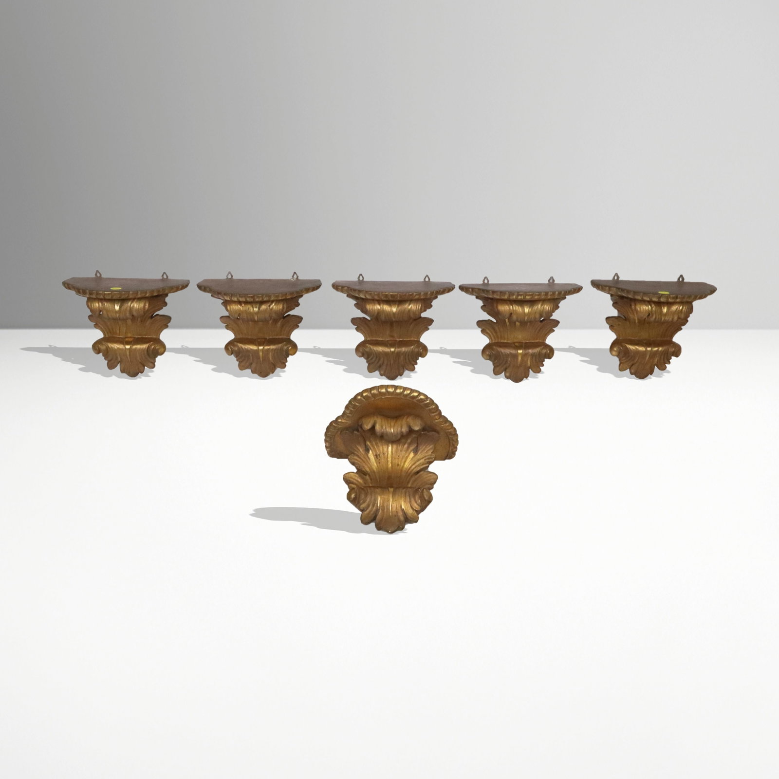 Set of Six Gilt Ceramic Wall Brackets: Set of six gilt ceramic wall brackets, the flowing scroll under a flat top with gadroon rim. [8" H x 9" W x 7" D]. Good condition.