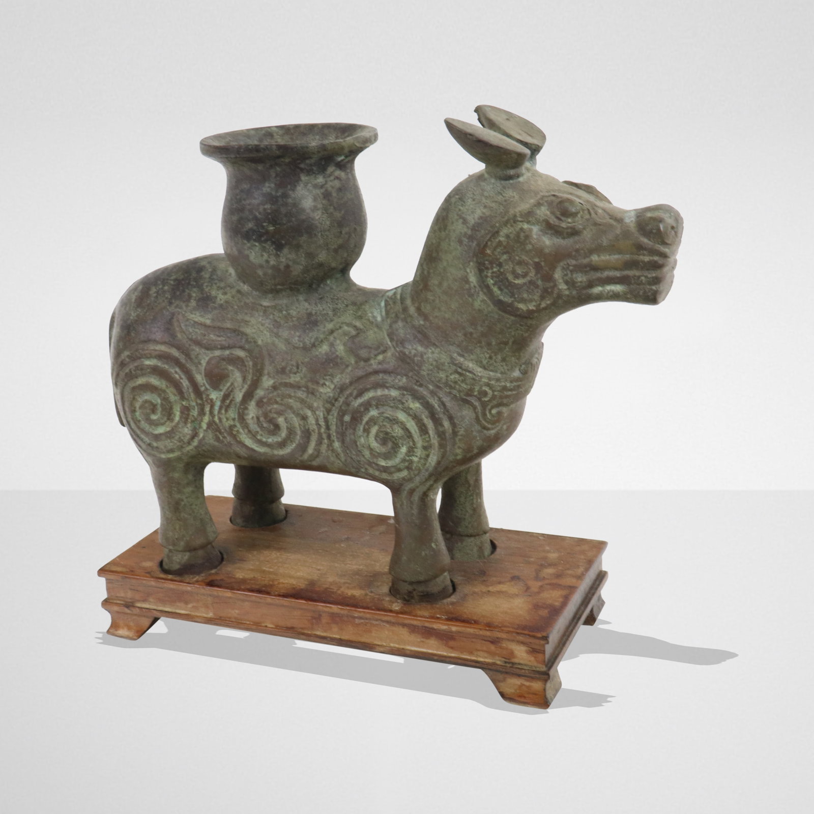 Archaic Bronze Animal Form Vessel: Archaic bronze animal form vessel, an open vase atop a beast of burden with adornments and designs. On fitted stand. [Bronze 6" H x 8" L x 3" W]. Good condition, aged.