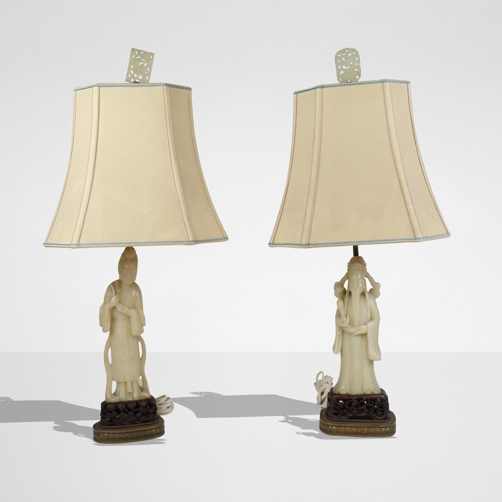 Pair of Chinese Carved Figures Mounted as Lamps: Pair of Chinese carved soapstone figures of Guanyin and Shou Lao, on pierced wood stands, resting on a gilt metal lamp based, with carved and pierced finials. [17.75" H to top of socket (excluding har