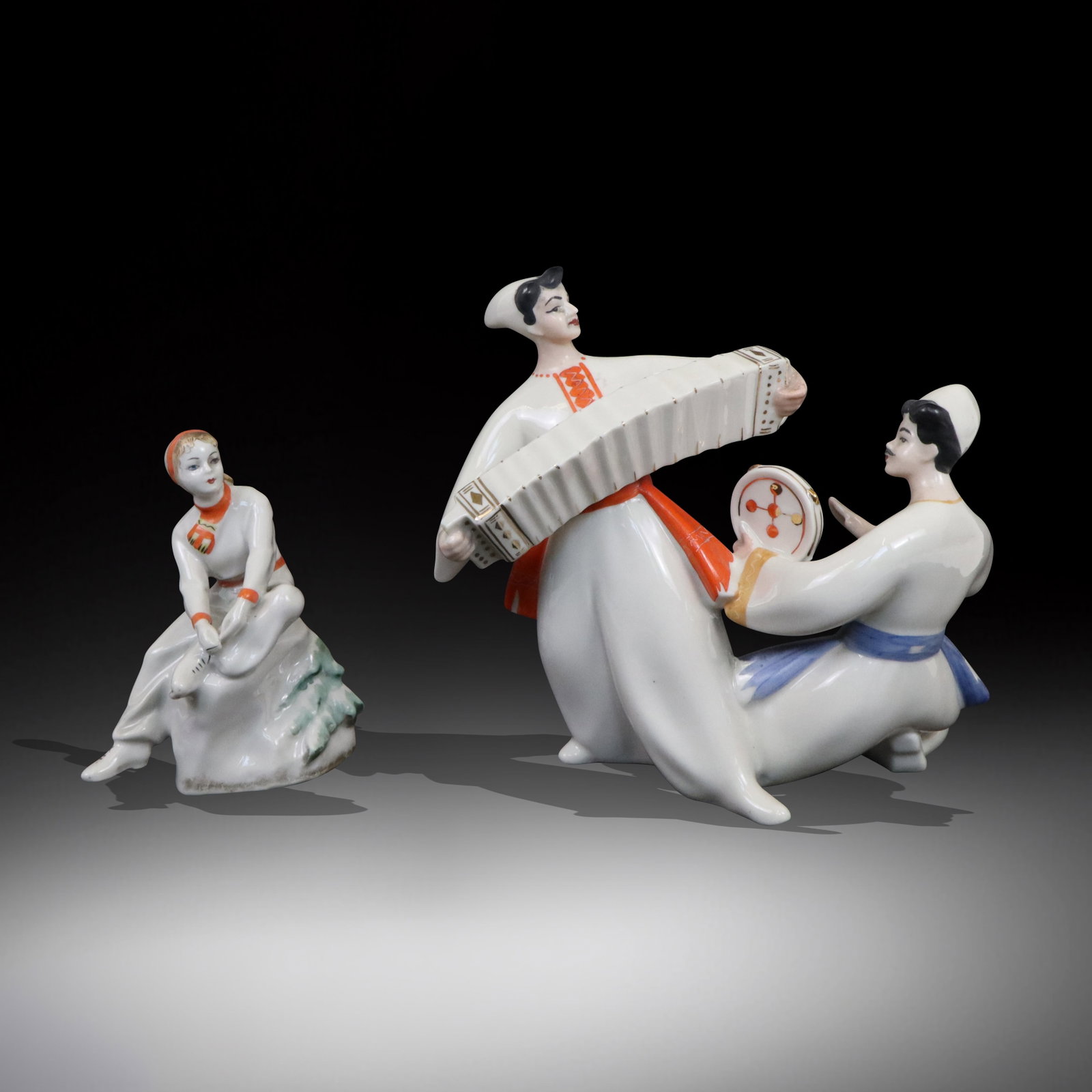 Two Mid-Century Russian Porcelain Groups: Two Russian porcelain groups; Woman tying ice skates - Made in Russia, and two musicians as one group - Made in USSR. [Group 8" H x 8" W x 4" D]. All good condition.
