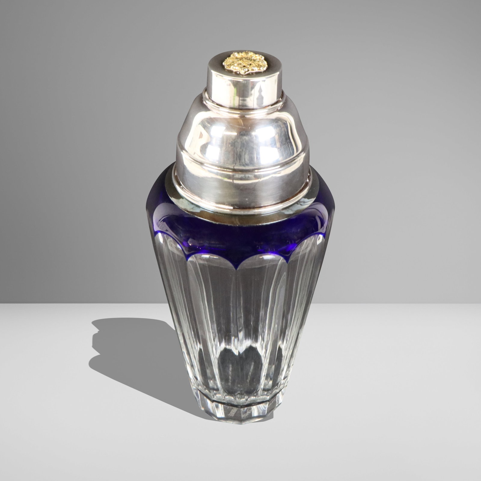 Faberge Crystal "Grand Duke" Cocktail Shaker: Faberge Art Deco inspired "Grand Duke" cobalt blue cut to clear glass cocktail shaker, with chrome lid, signed on base. [8" H x 3.5" Diameter]. Overall condition is good, with signs of normal wear.