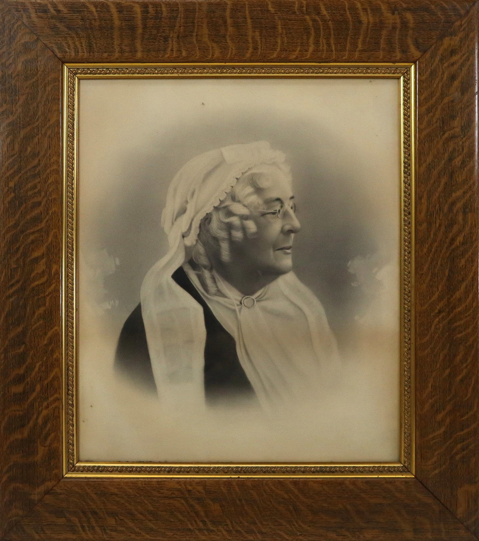 Oak Framed Antique Print, Portrait of a Woman: Oak framed antique print depicting a side profile portrait of a woman in a bonnet, no apparent signature or known origin. [Sight: 23.5" H x 19.5" W; Frame: 33" H x 29" W]. Toning, otherwise fine condi